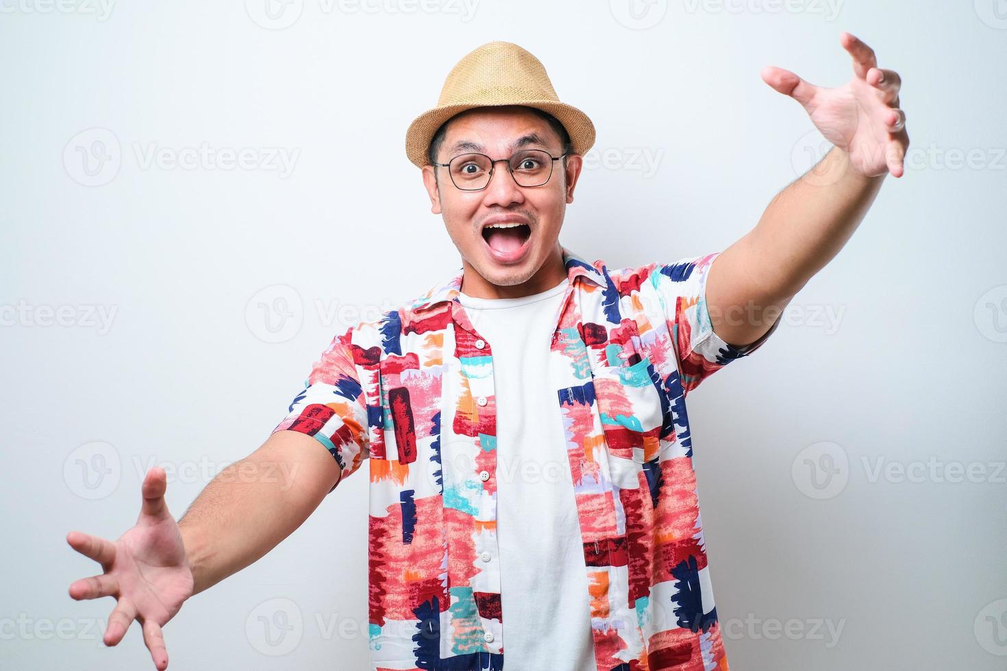 jonge knappe aziatische man met een casual strandshirt die naar de camera kijkt en lacht met open armen voor een knuffel. foto