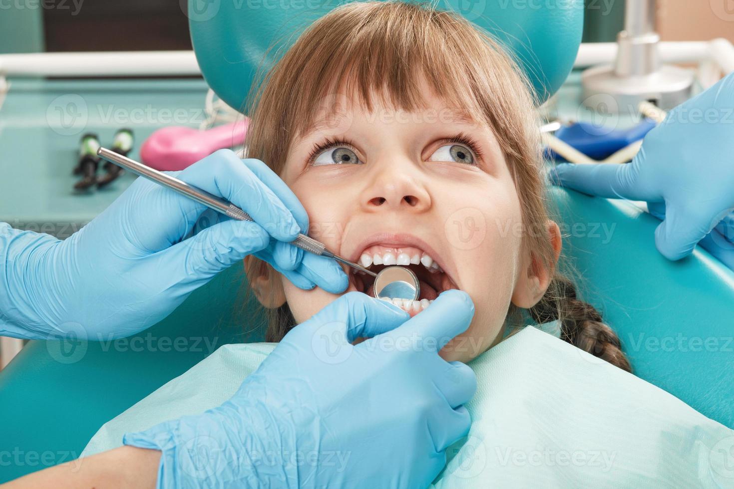 close-up van meisje met haar tanden gecontroleerd door niet-geïdentificeerde foto