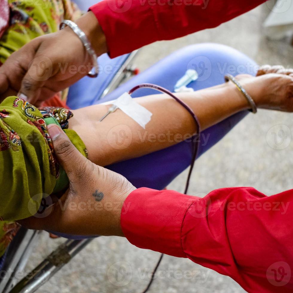bloeddonor in bloeddonatiekamp gehouden met een springkussen in de hand in balaji-tempel, vivek vihar, delhi, india, afbeelding voor wereldbloeddonordag op 14 juni elk jaar, bloeddonatiekamp foto