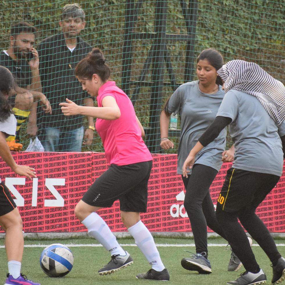 New Delhi, India - juli 01 2018 - vrouwelijke voetballers van het lokale voetbalteam tijdens het spel in het regionale derbykampioenschap op een slecht voetbalveld. heet moment van voetbalwedstrijd op grasgroen veldstadion foto