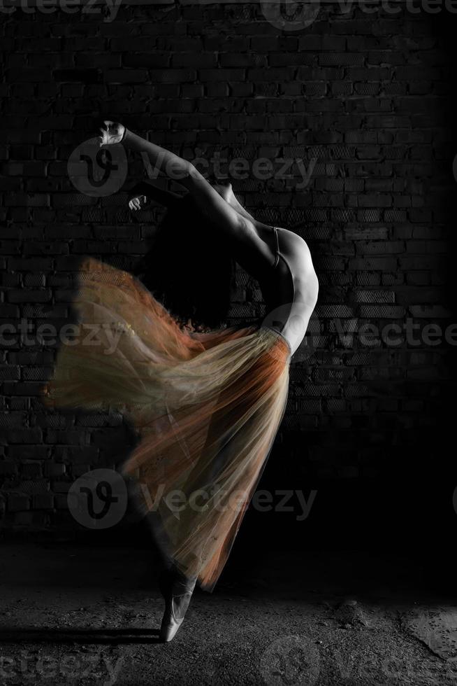 een charmante ballerina in een bodysuit poseert balletelementen in een hoofdtooi in een fotostudio foto