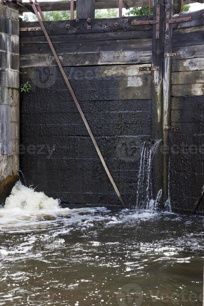 een lekkend deel van een oude houten dam foto