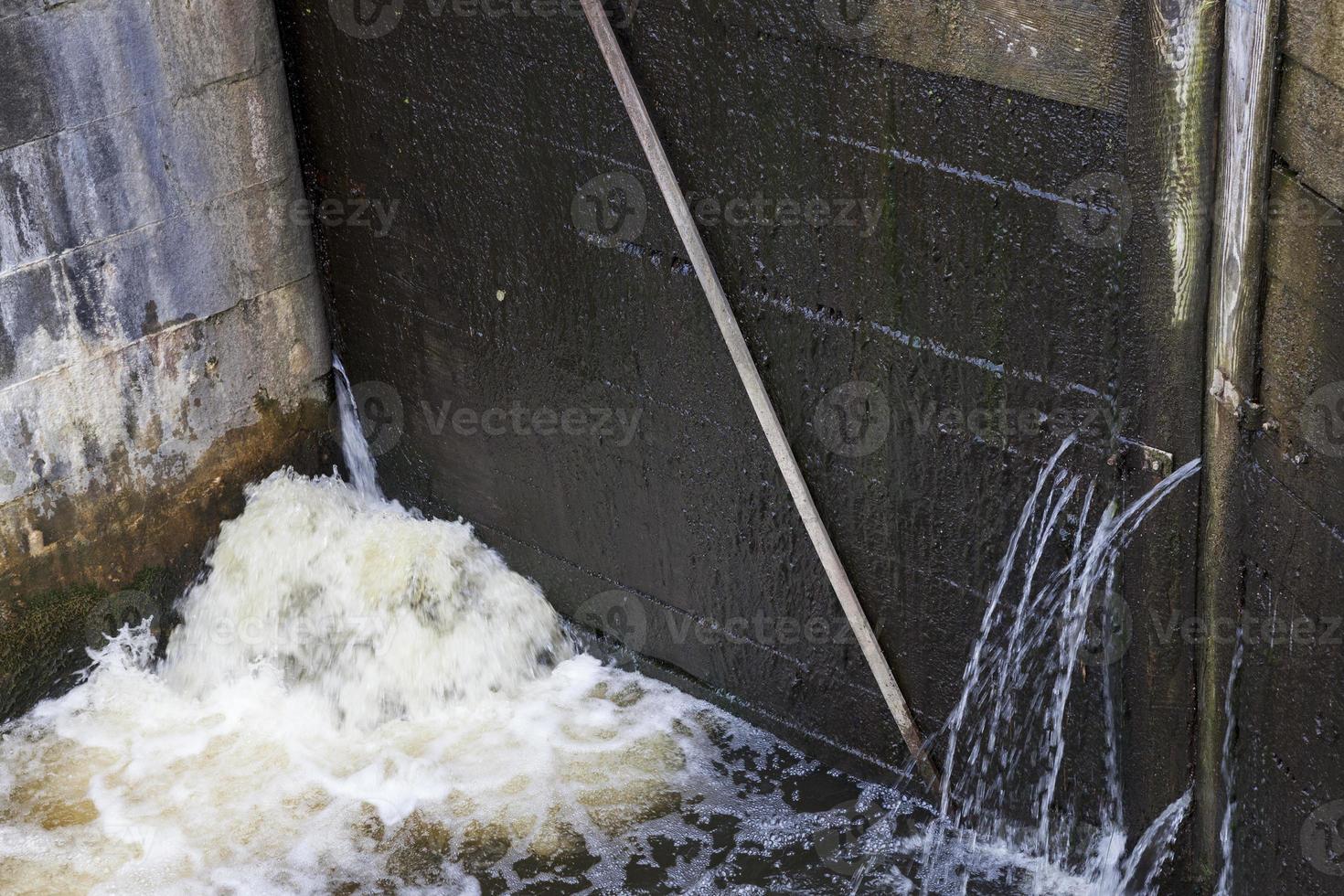 een lekkend deel van een oude houten dam foto