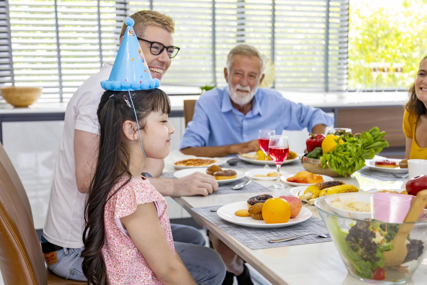 verjaardagsfeestje voor kleine meisjes met het hele gezin van een andere generatie en buurman die samenkomen in een feestmaaltijd foto