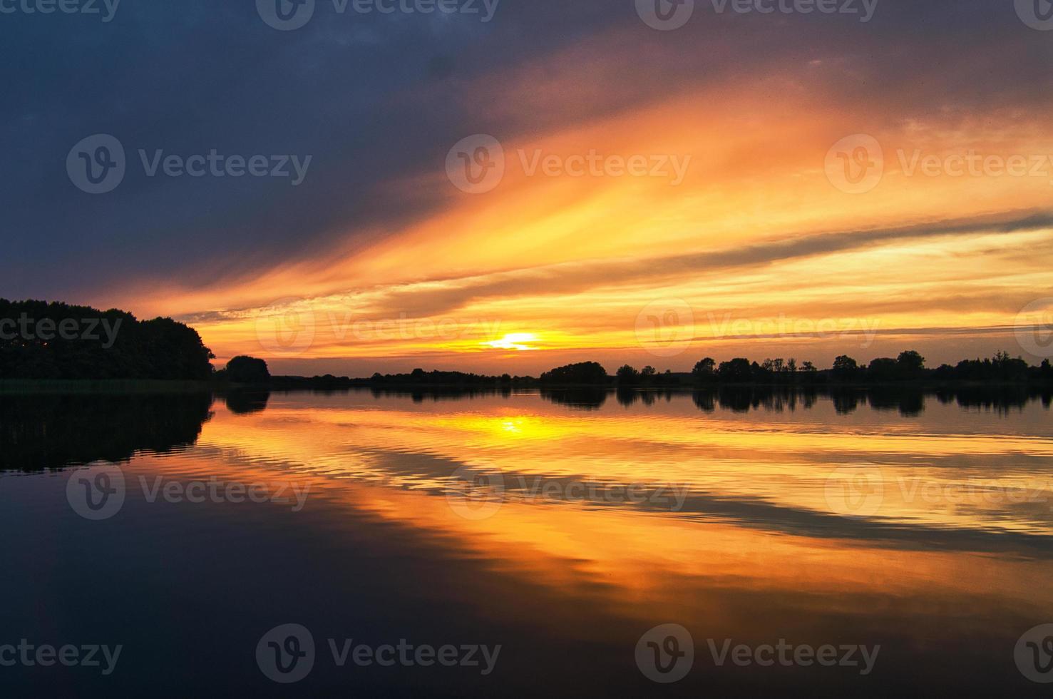 weerspiegeling van de lucht in het water. goud, geel en roze kleuren van de lucht worden weerspiegeld in het meer. foto