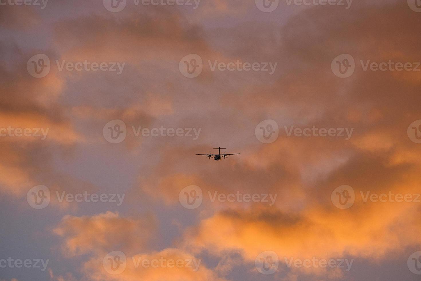 vliegtuig in de avondlucht in lichtgevende horizon. het gaat op vakantie foto