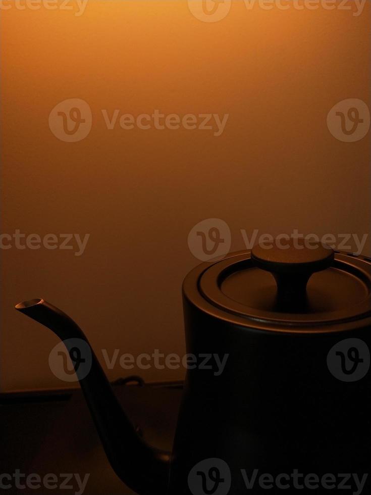 silhouetfoto van een theepot op een gele tot gouden achtergrond foto