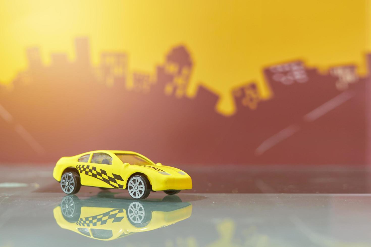 gele raceauto speelgoed selectieve focus op wazige stadsachtergrond foto