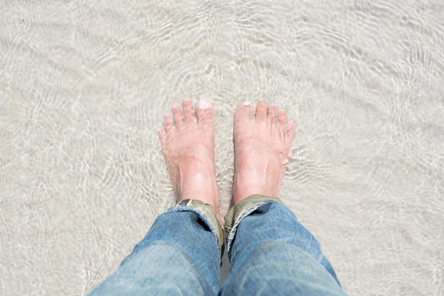 de voeten in het zeewater. de voeten genieten van de zee! foto
