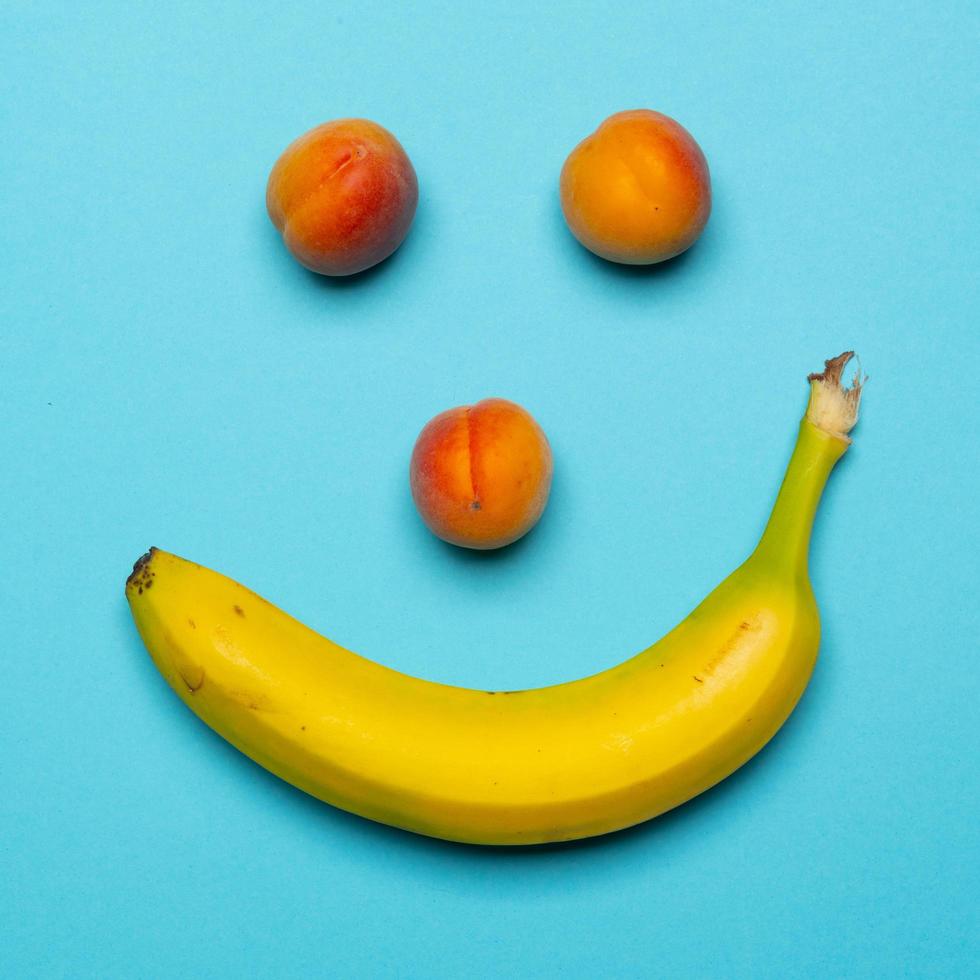 banaan en perziken blij gezicht stilleven foto