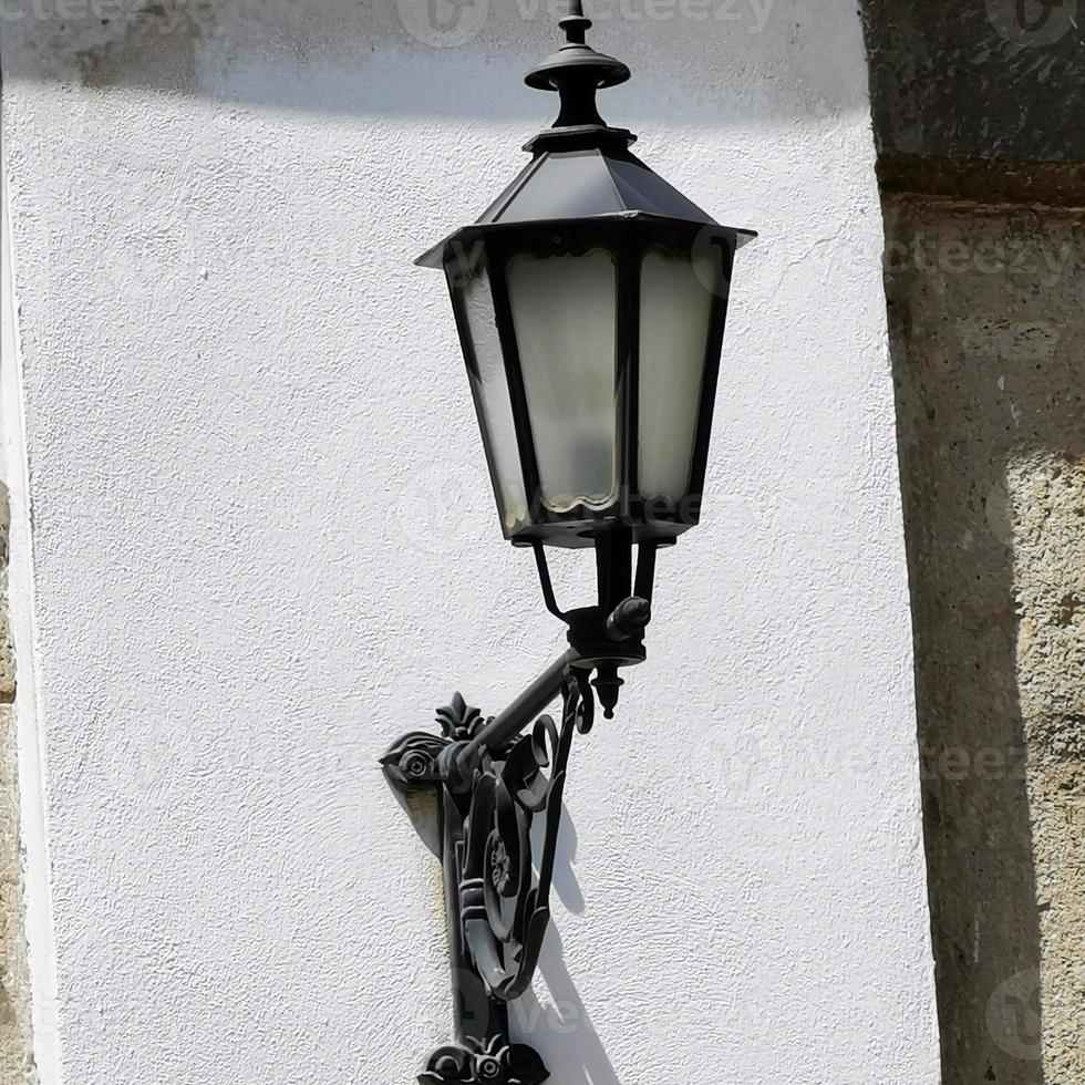 een lamp die aan de zijkant van een gebouw hangt foto