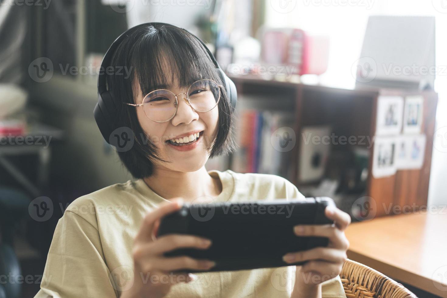 nerd-stijl jonge volwassen Aziatische gamer-vrouw draagt een bril en hoofdtelefoon speel een online game foto