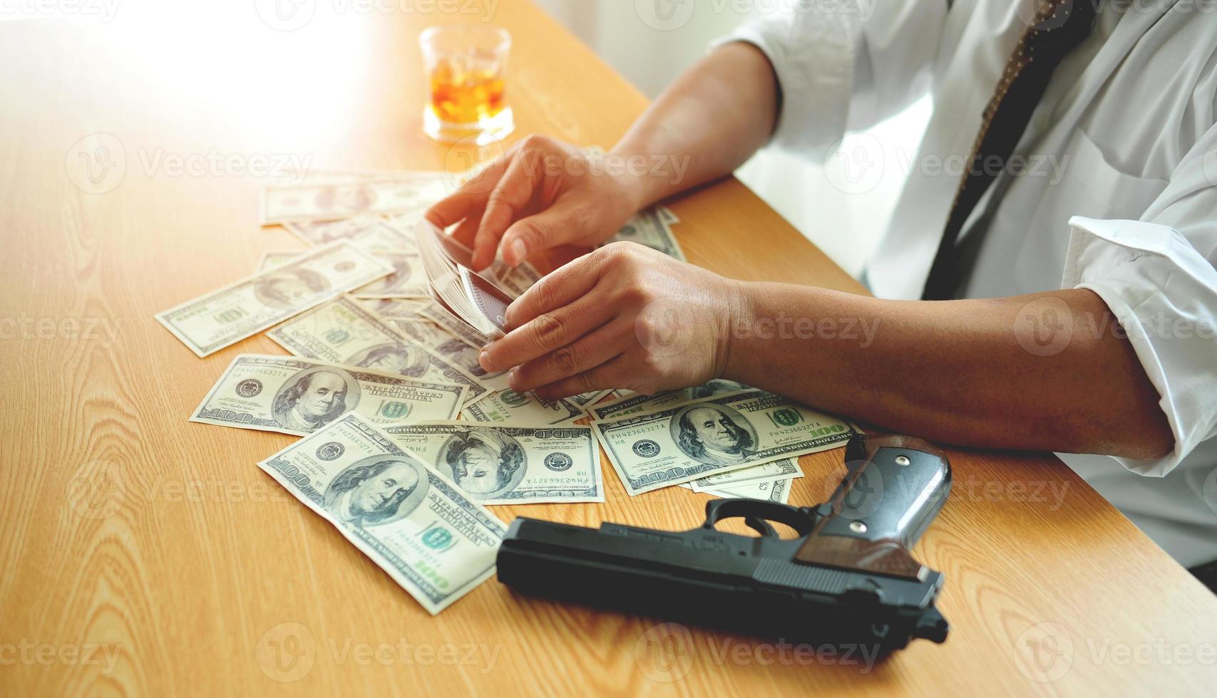 gokker speelt kaarten en oefent goktactieken met geld en sterke drank op zijn tafel foto