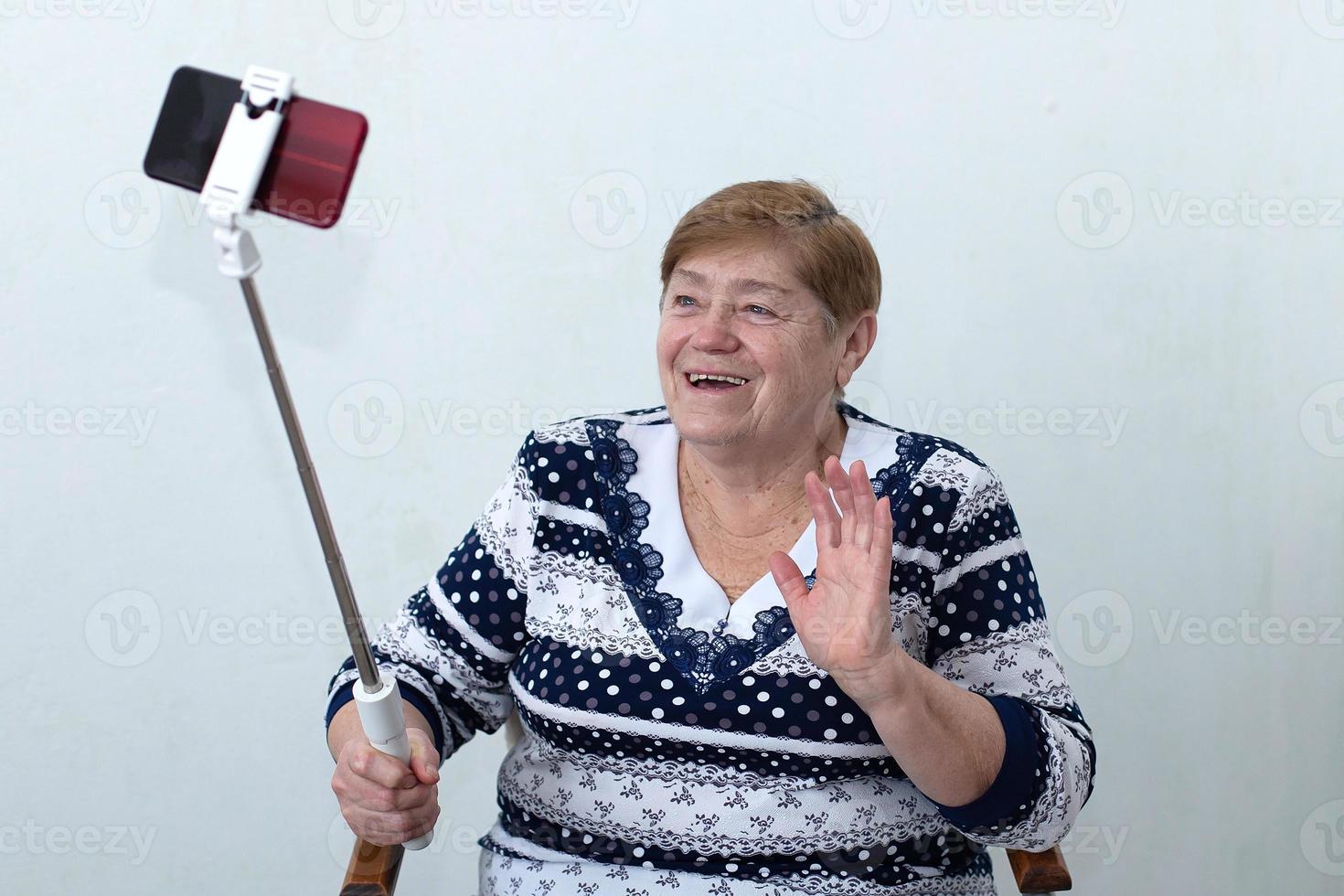 een oudere vrouw schrijft een video voor een blog foto