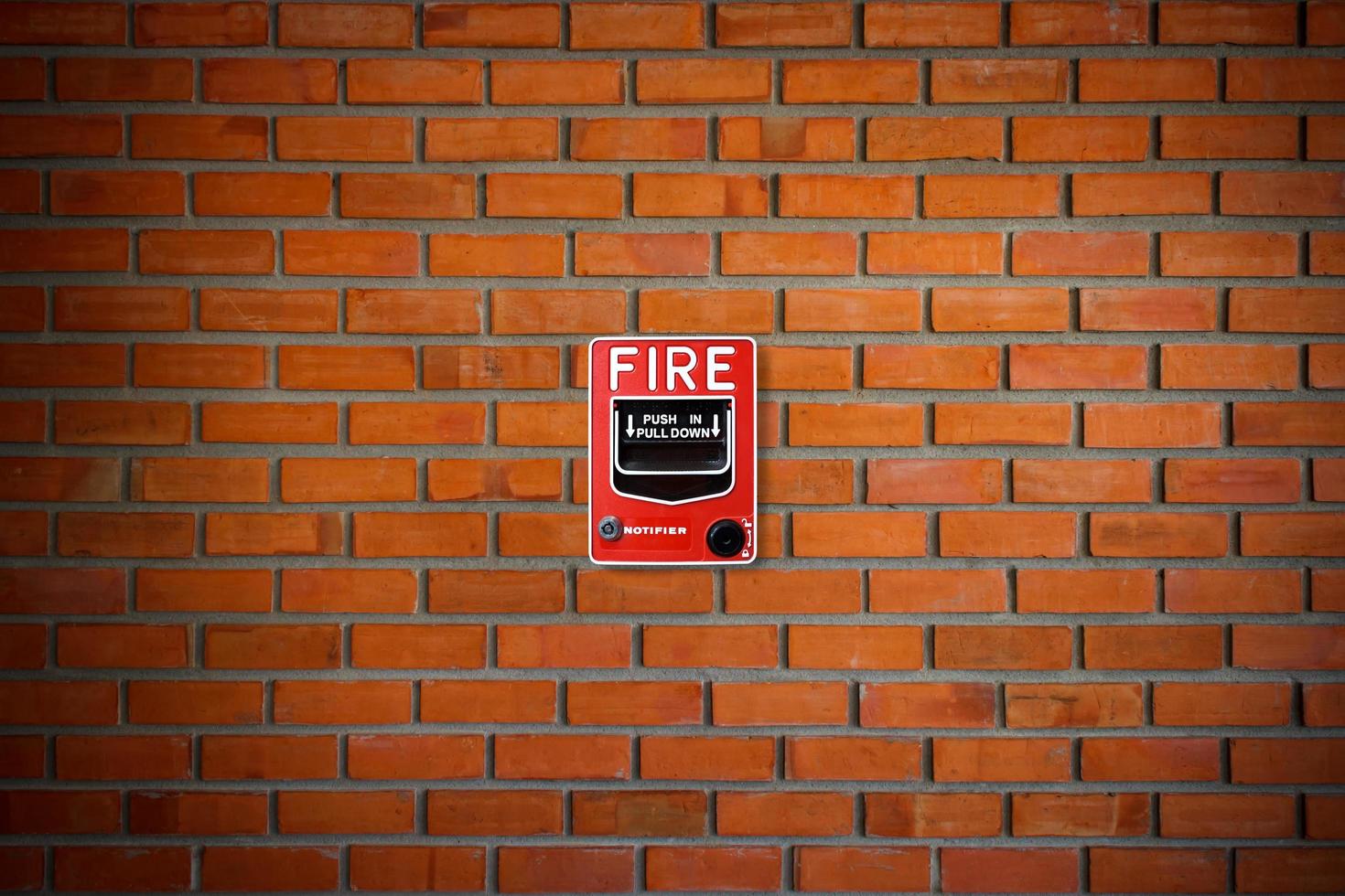 brandalarm schakelaar op bakstenen muur textuur achtergrond foto