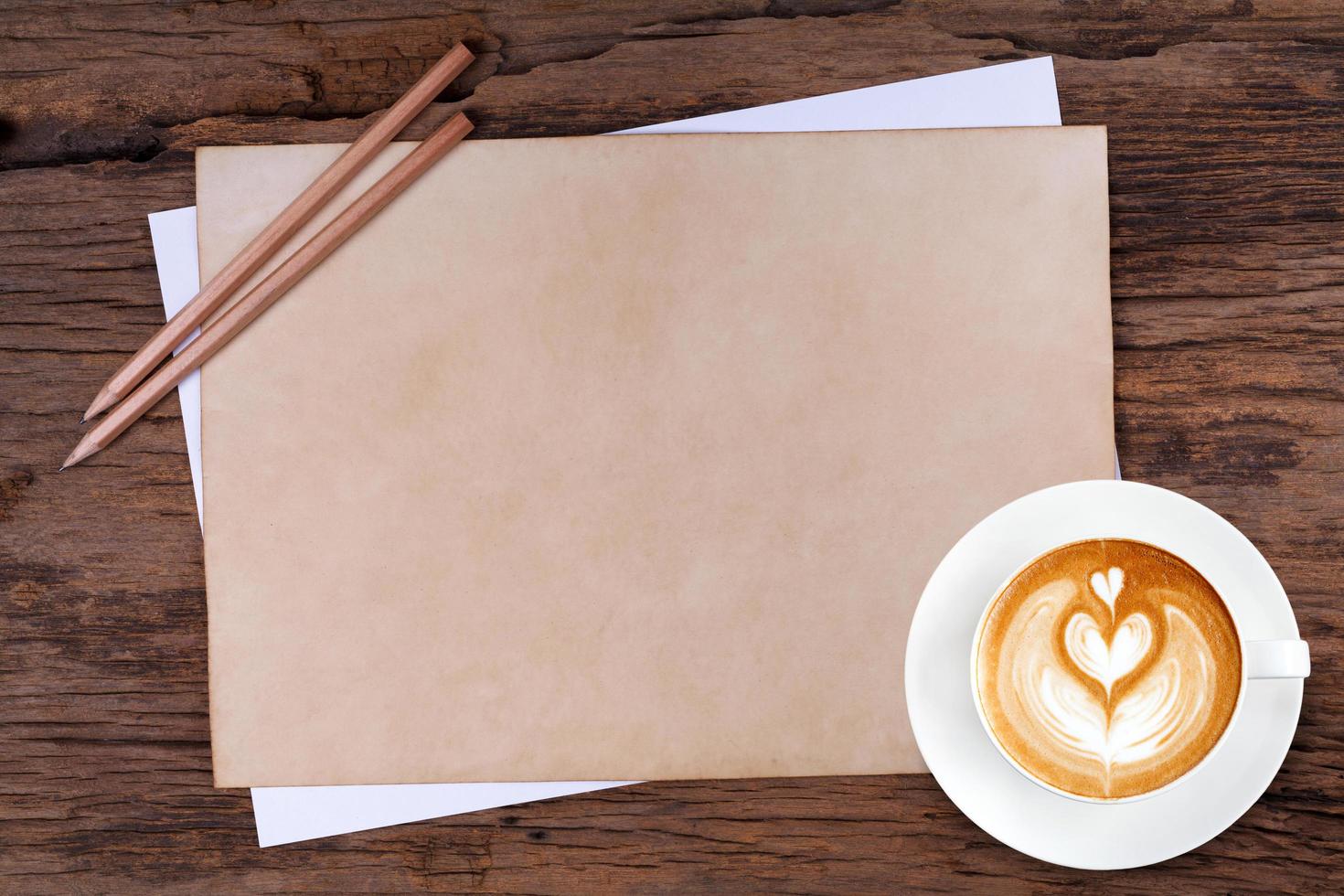 blanco papier met potlood en een kopje koffie op houten foto