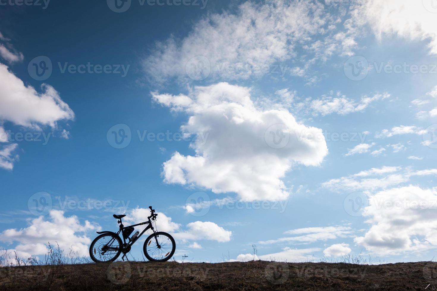 fiets silhouet in blauwe lucht met wolken. symbool van onafhankelijkheid en vrijheid foto