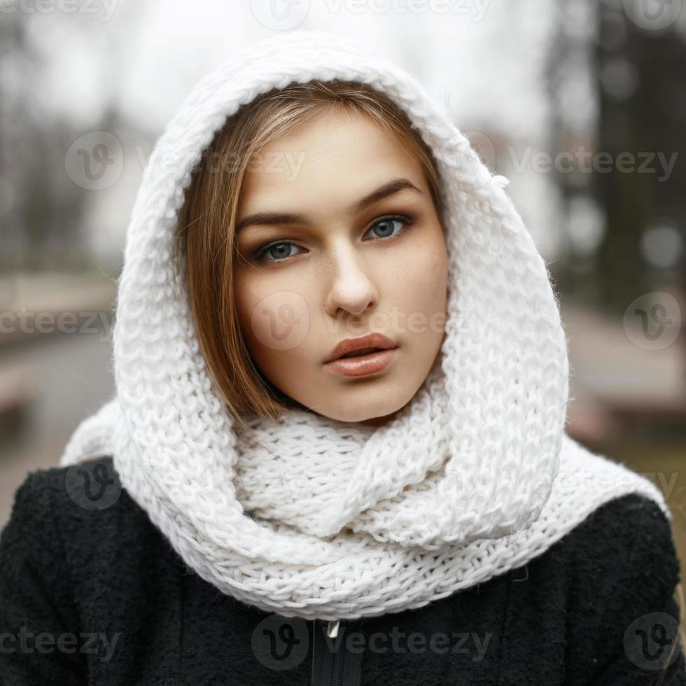 jong mooi meisje in een witte gebreide sjaal in herfstdag foto