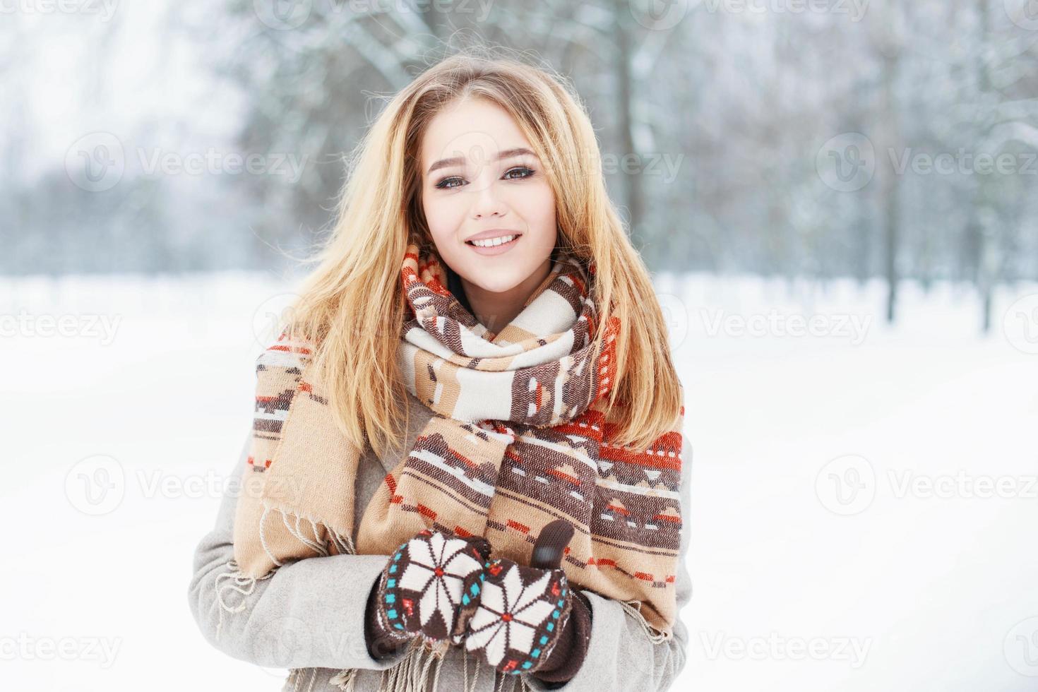 jong mooi meisje met een schattige glimlach in vintage sjaal en wanten in winterdag foto