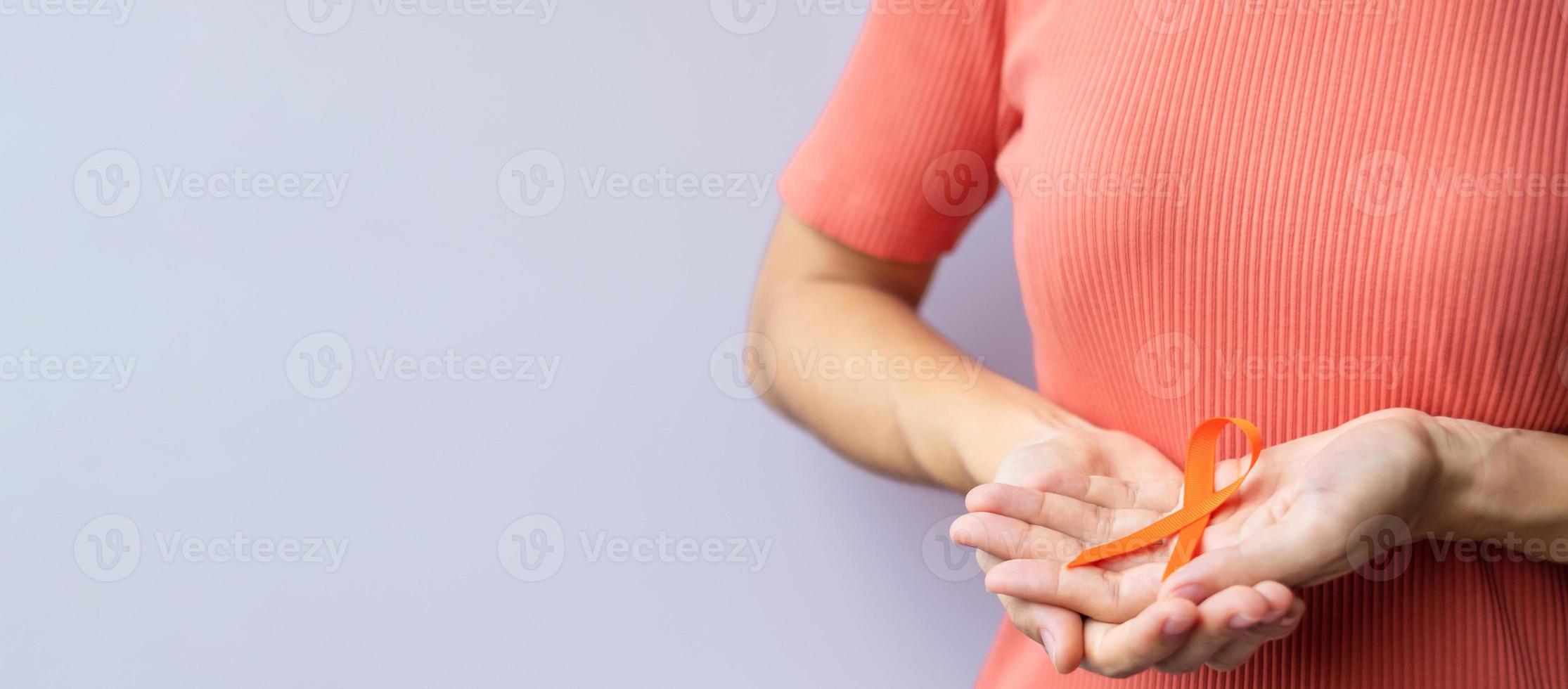 oranje lint voor leukemie, nierkankerdag, wereld multiple sclerose, crps, zelfverwondingsmaand. gezondheidszorg en woord kanker dag concept foto