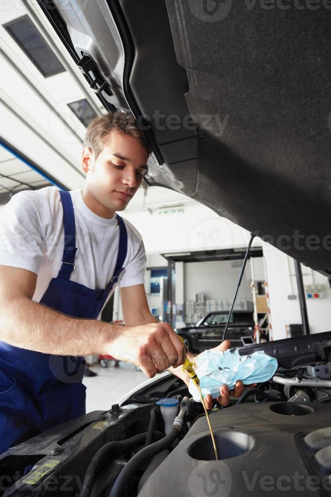 monteur aan het werk oliepeil controleren op de motor van een auto foto