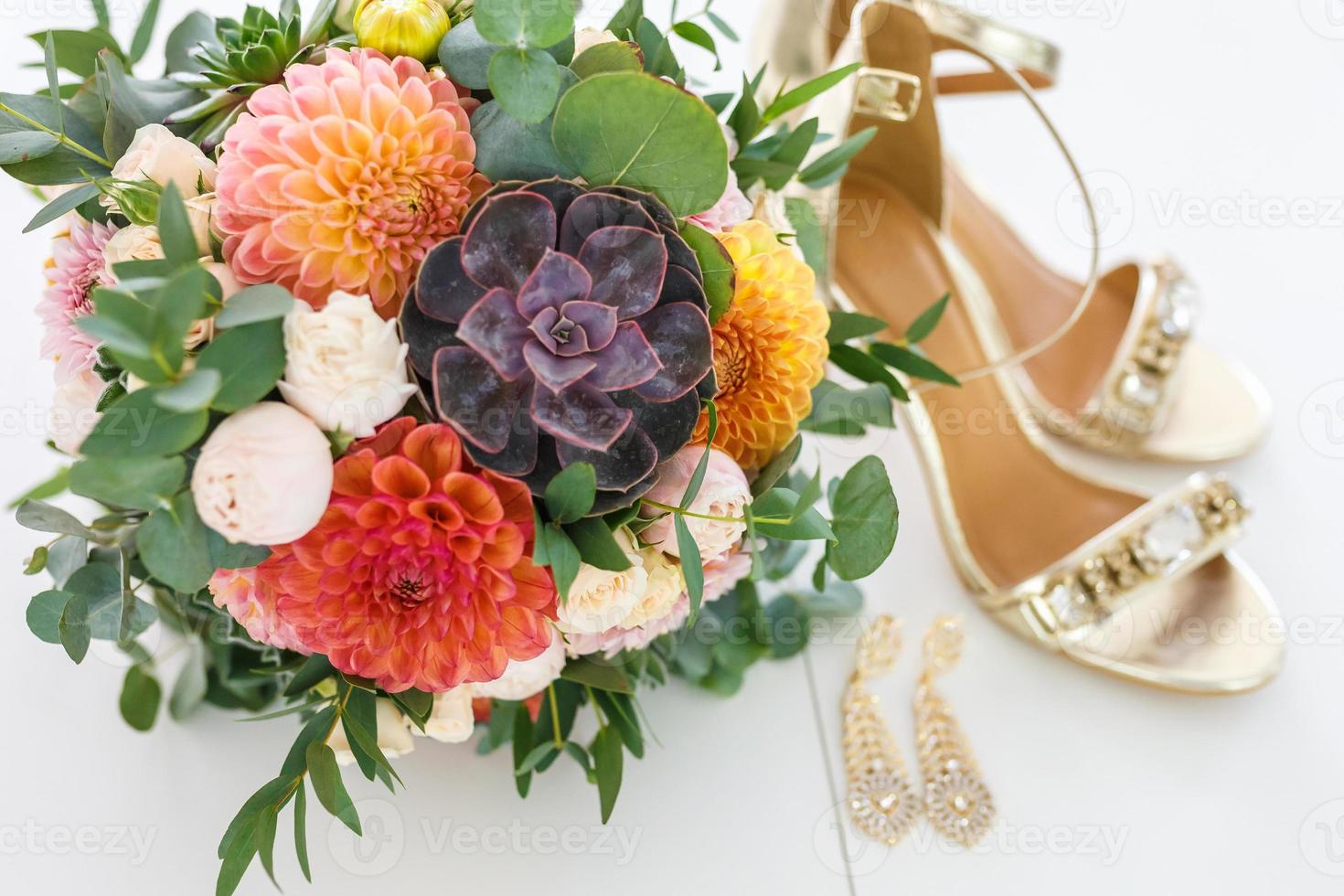 helder huwelijksboeket van zomerdahlia's en rozen met schoenen met hoge hakken voor dames foto