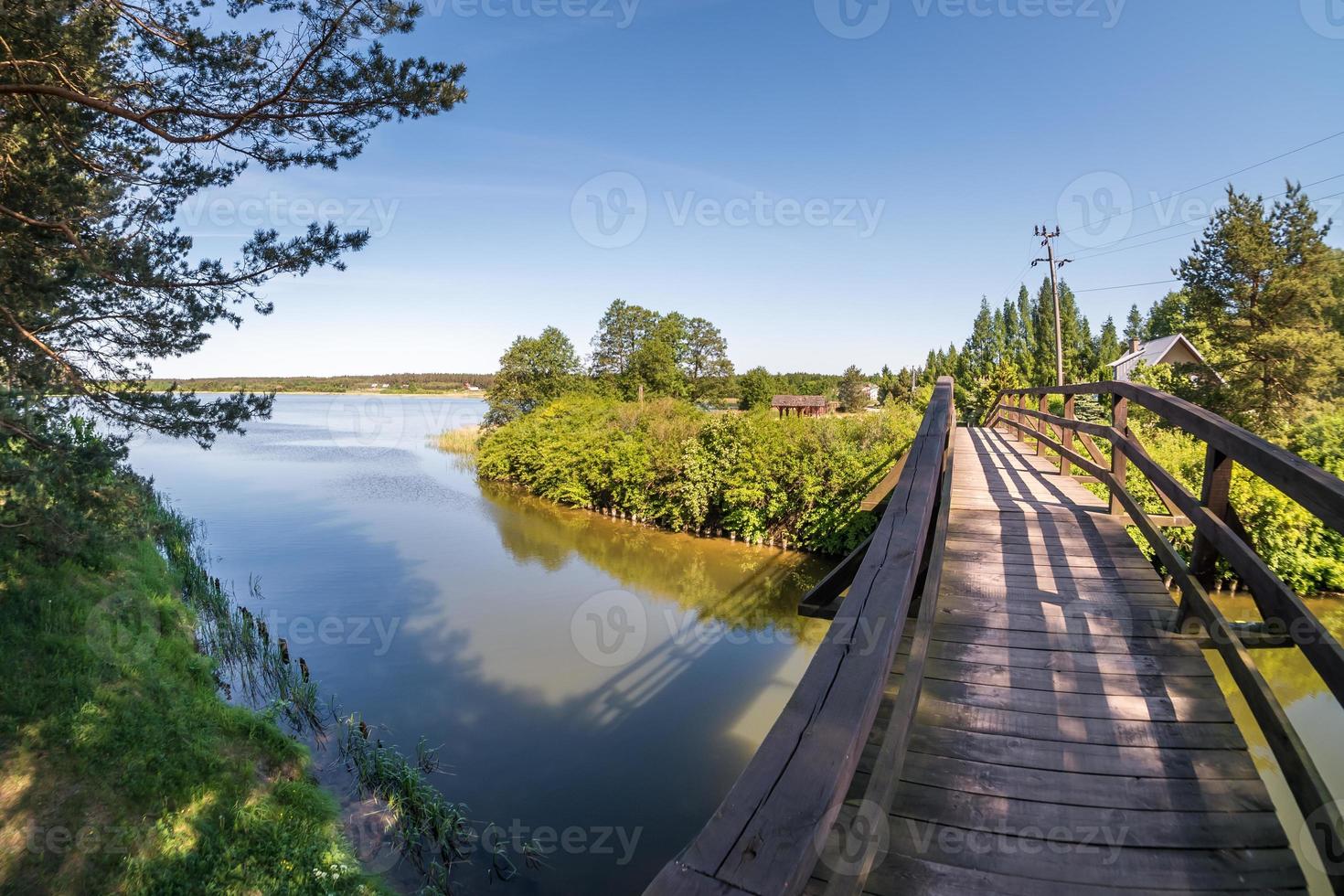 oude houten brug over het rivierkanaal tegen de achtergrond van het meer foto