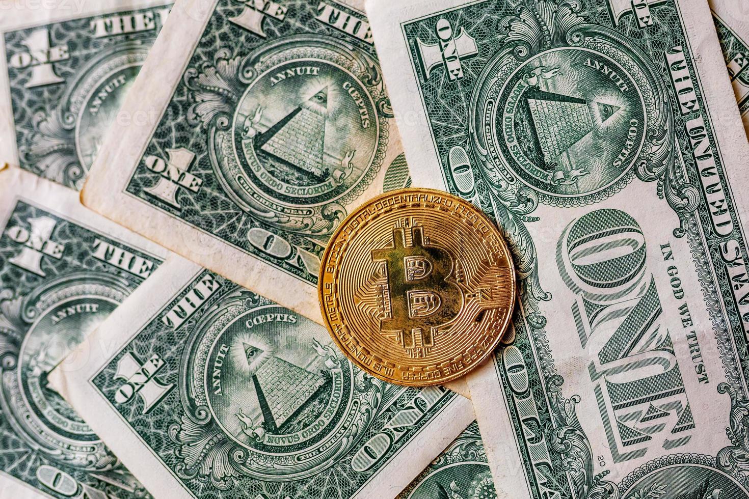 virtueel geld gouden bitcoin op de achtergrond van één dollarbiljet. concept van nieuwe wereldorde van cryptocurrency. wissel bitcoin contant in voor een dollar. foto