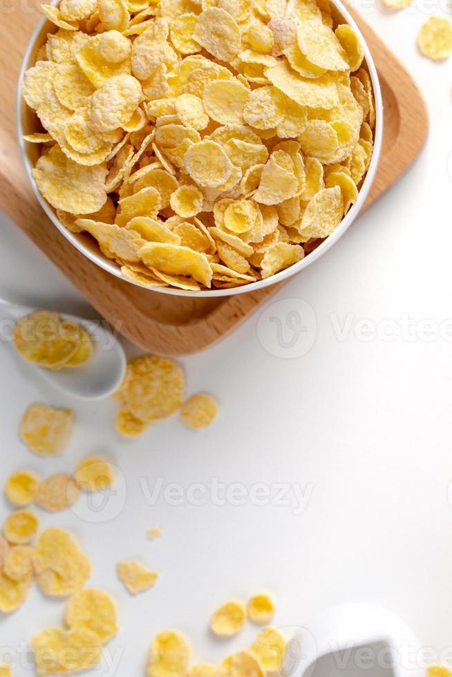 bovenaanzicht van cornflakes kom met melk op witte achtergrond. foto