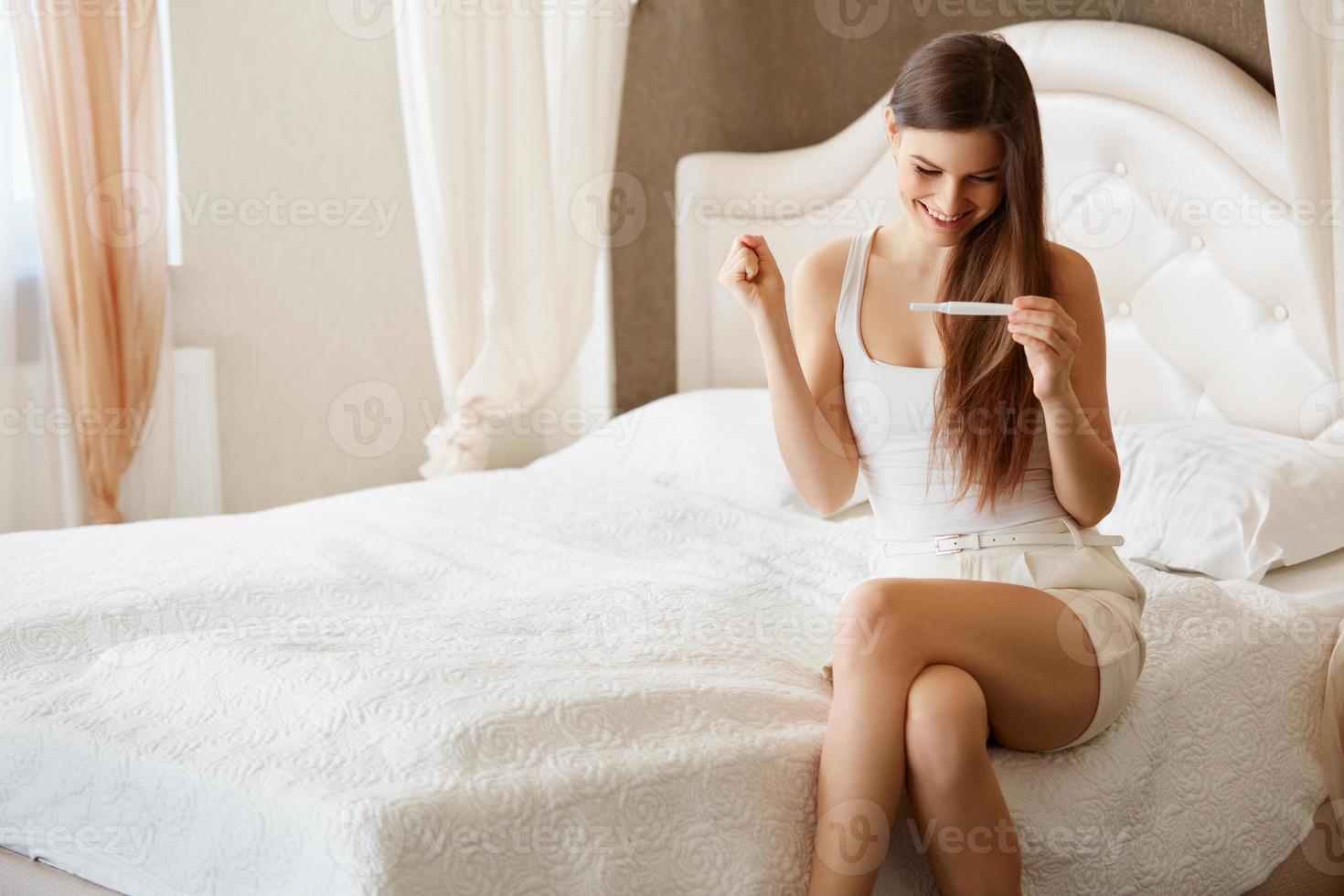 gelukkige vrouw met zwangerschapstest foto