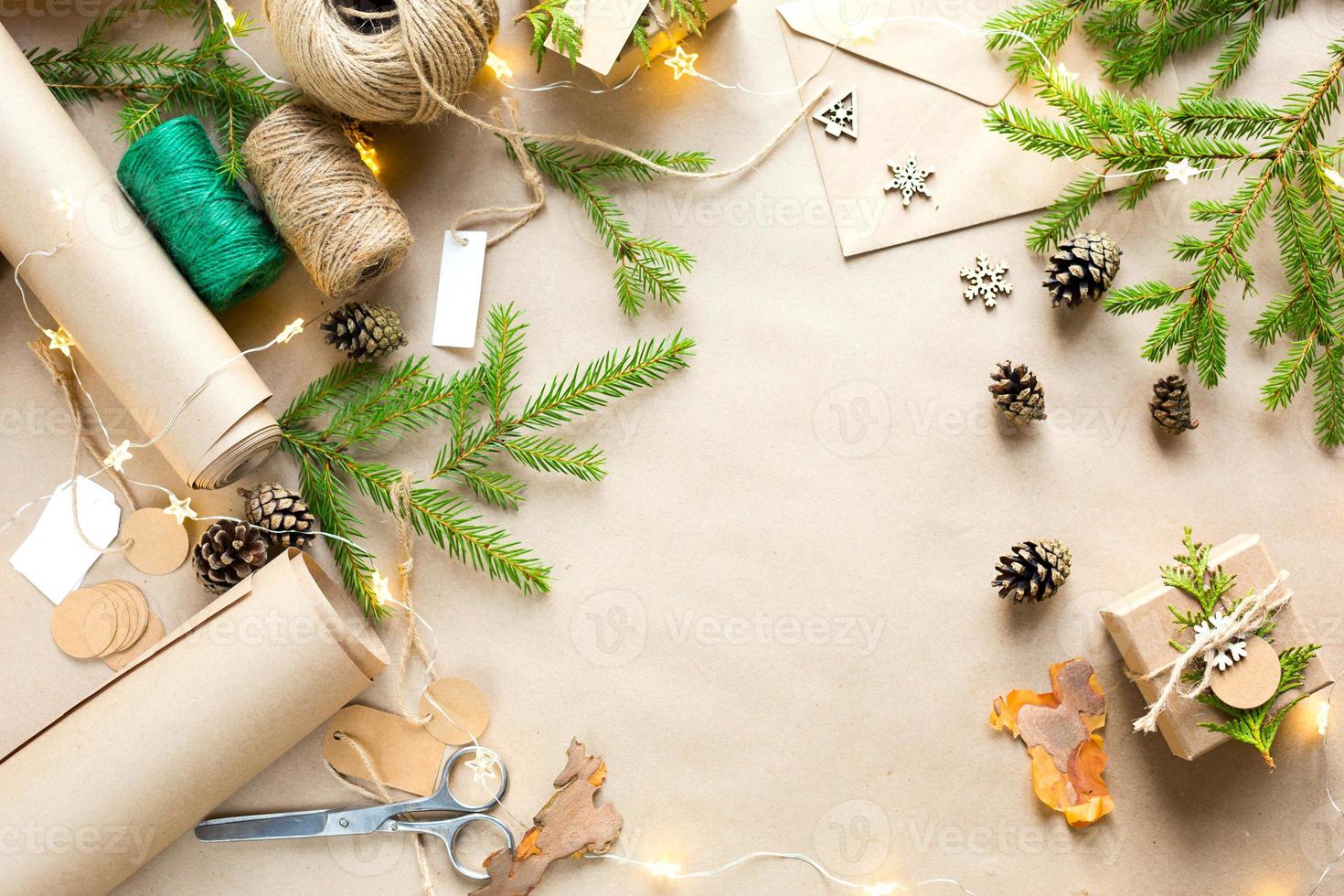 achtergrond met copyspace voor kerstmis en nieuwjaar in milieuvriendelijke materialen kraftpapier, geschenkdoos, levende dennentakken, kegels, touw. tags met mock-up, natuurlijk decor, handgemaakt, diy. botweg foto