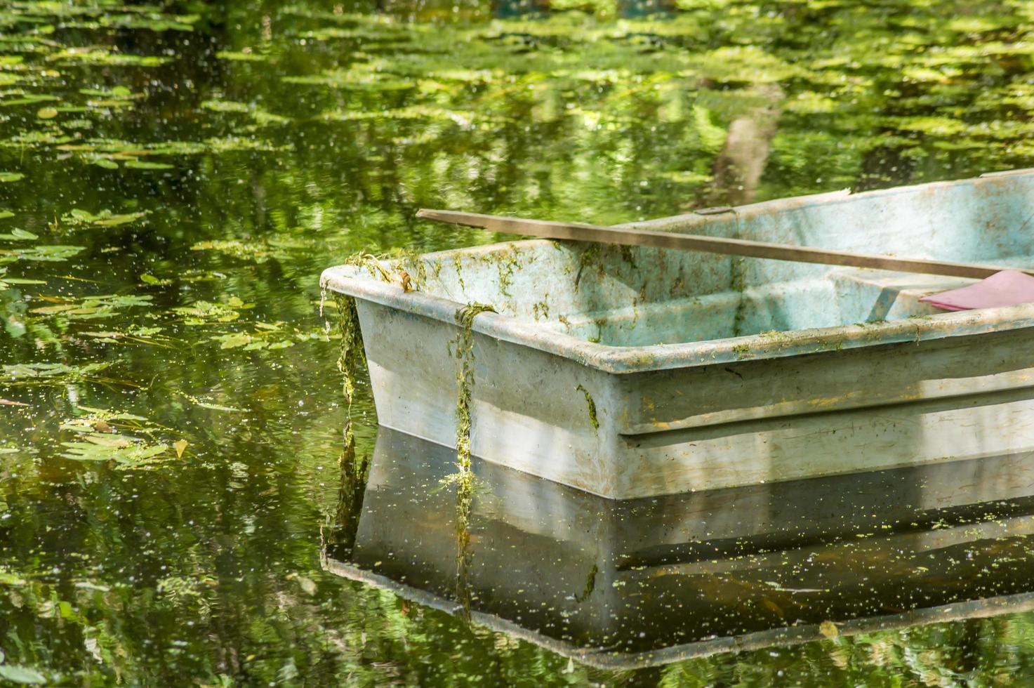 oude groene roeiboot in een tuinvijver foto