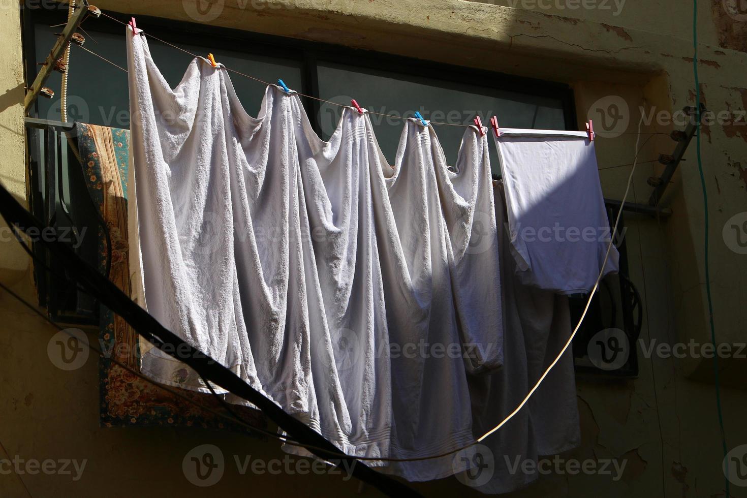 gewassen linnen droogt op straat buiten het raam van het huis. foto