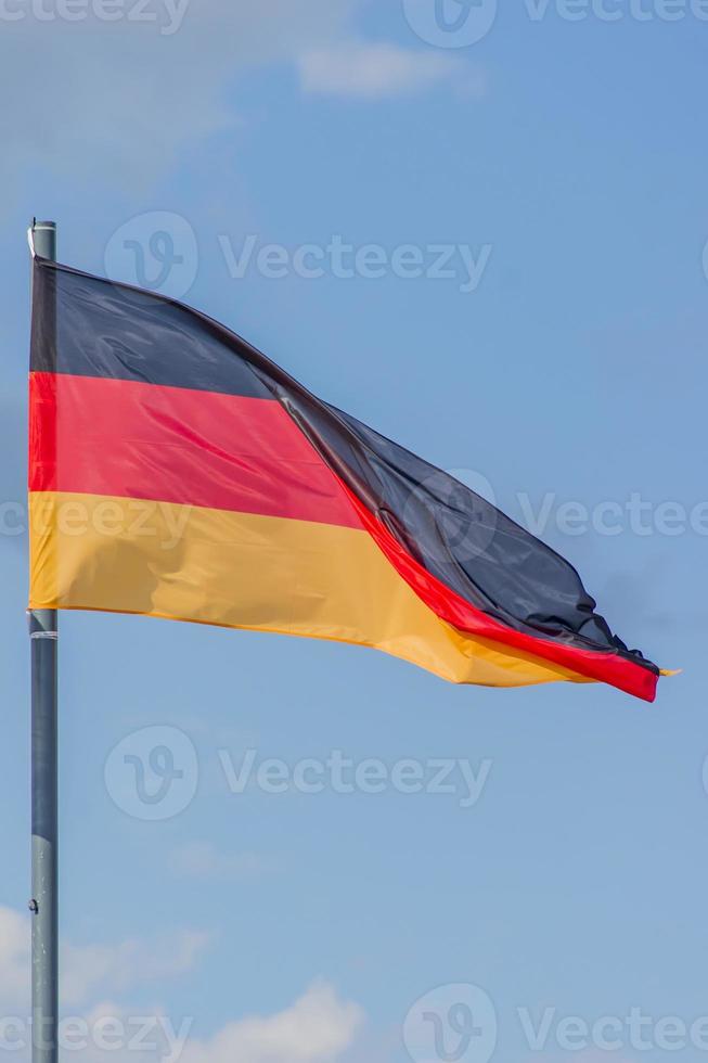 de nationale vlag van duitsland wappert over de blauwe lucht foto