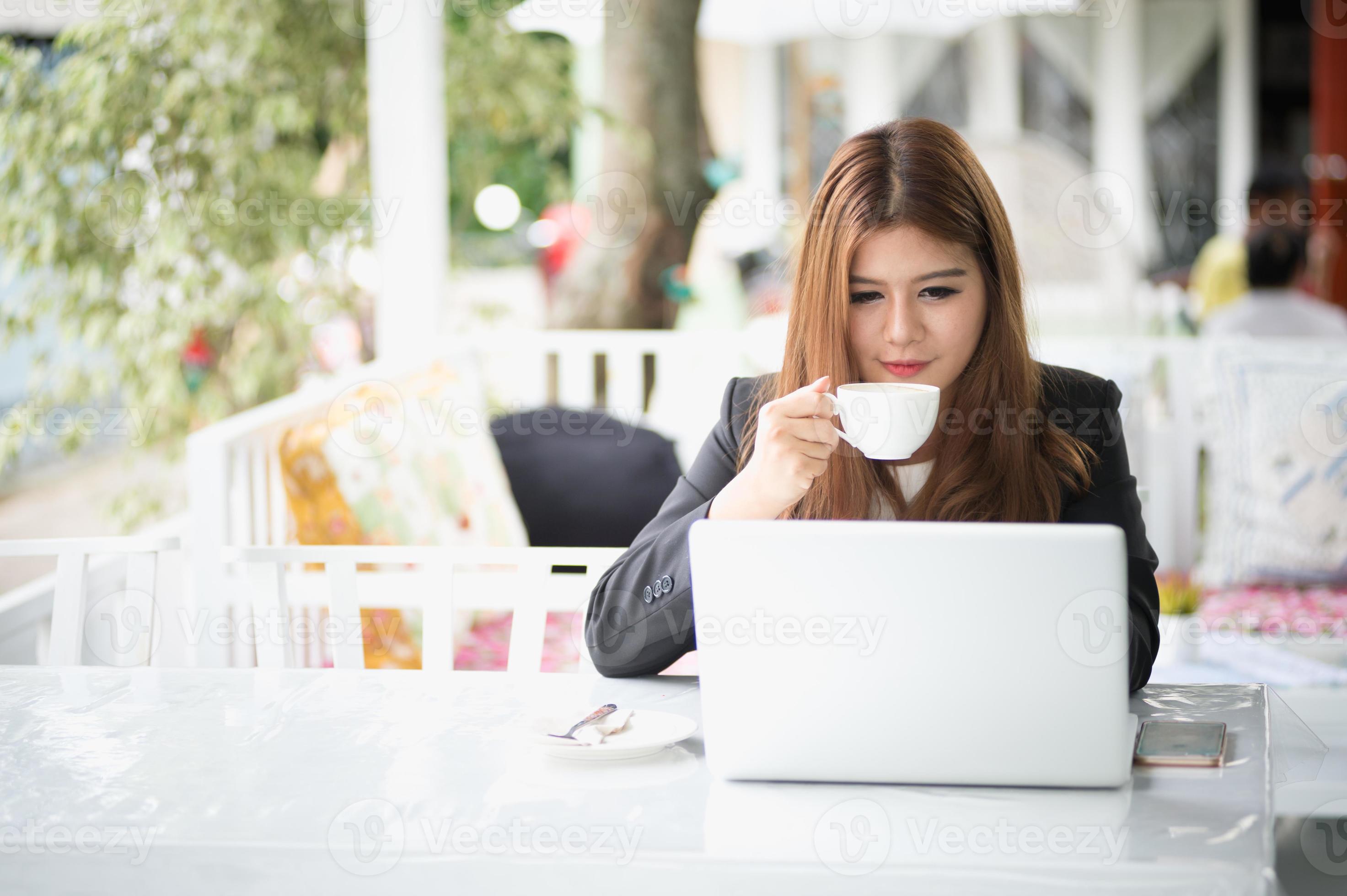 Azië vrouw in café met laptop en koffie, bedrijfsconcept foto