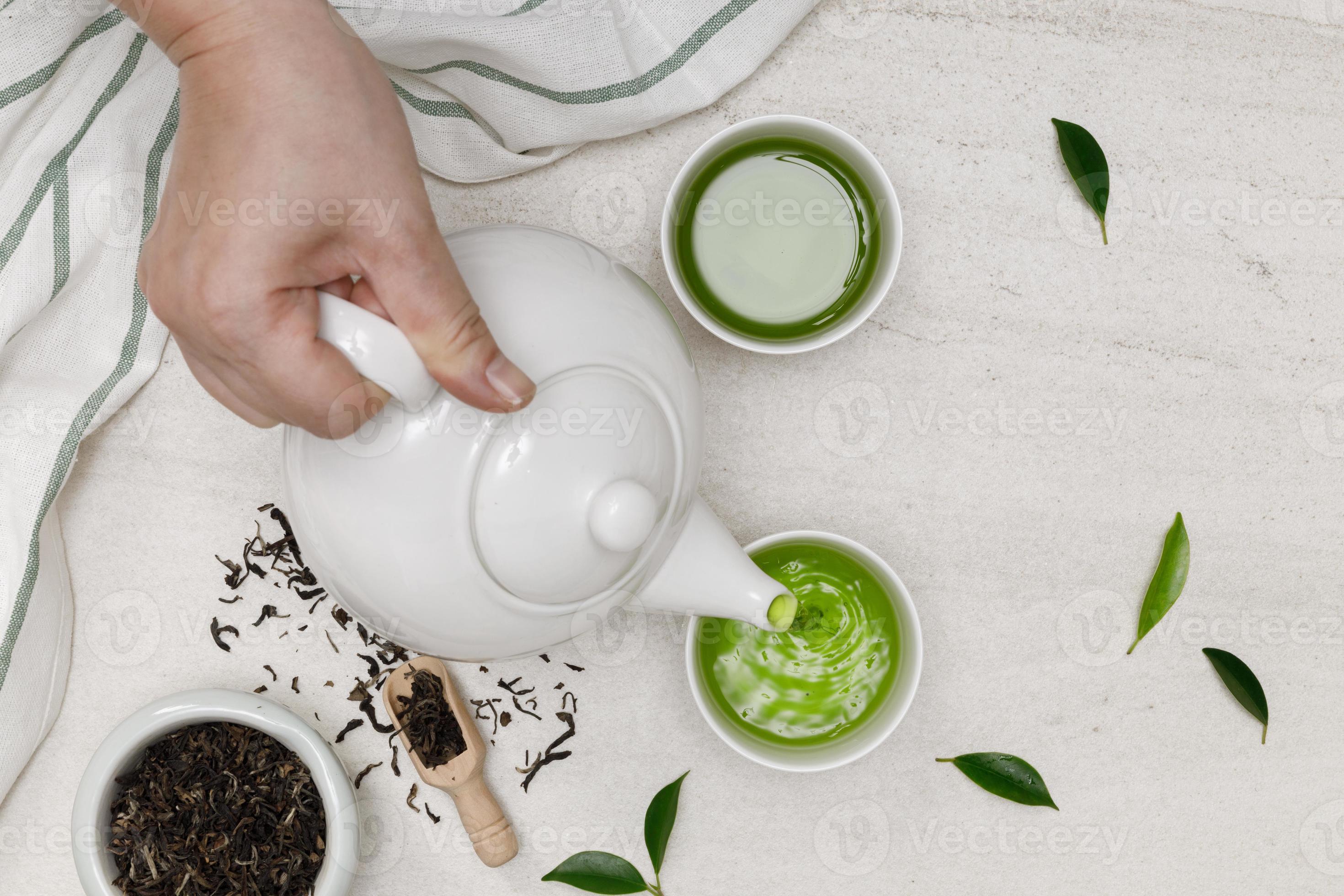 hand- gieten heet stomen thee in kop van theepot droog kruid thee Aan de wit steen tafel creatief leggen, biologisch Product van de natuur voor gezond met traditioneel stijl 11568265 Stockfoto