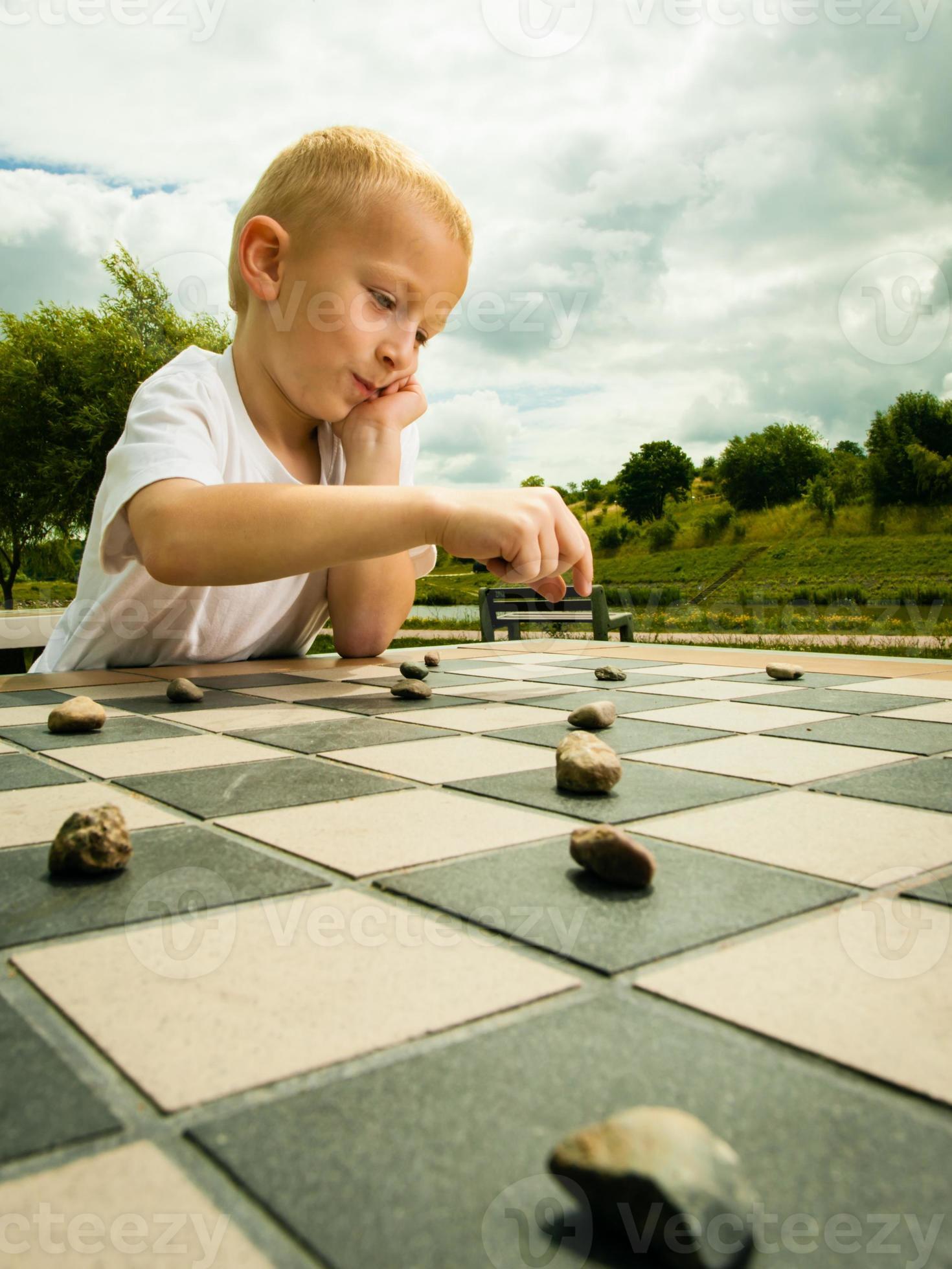 Meedogenloos kassa hoogtepunt kind spelen dammen of dammen bordspel buiten 1238536 Stockfoto