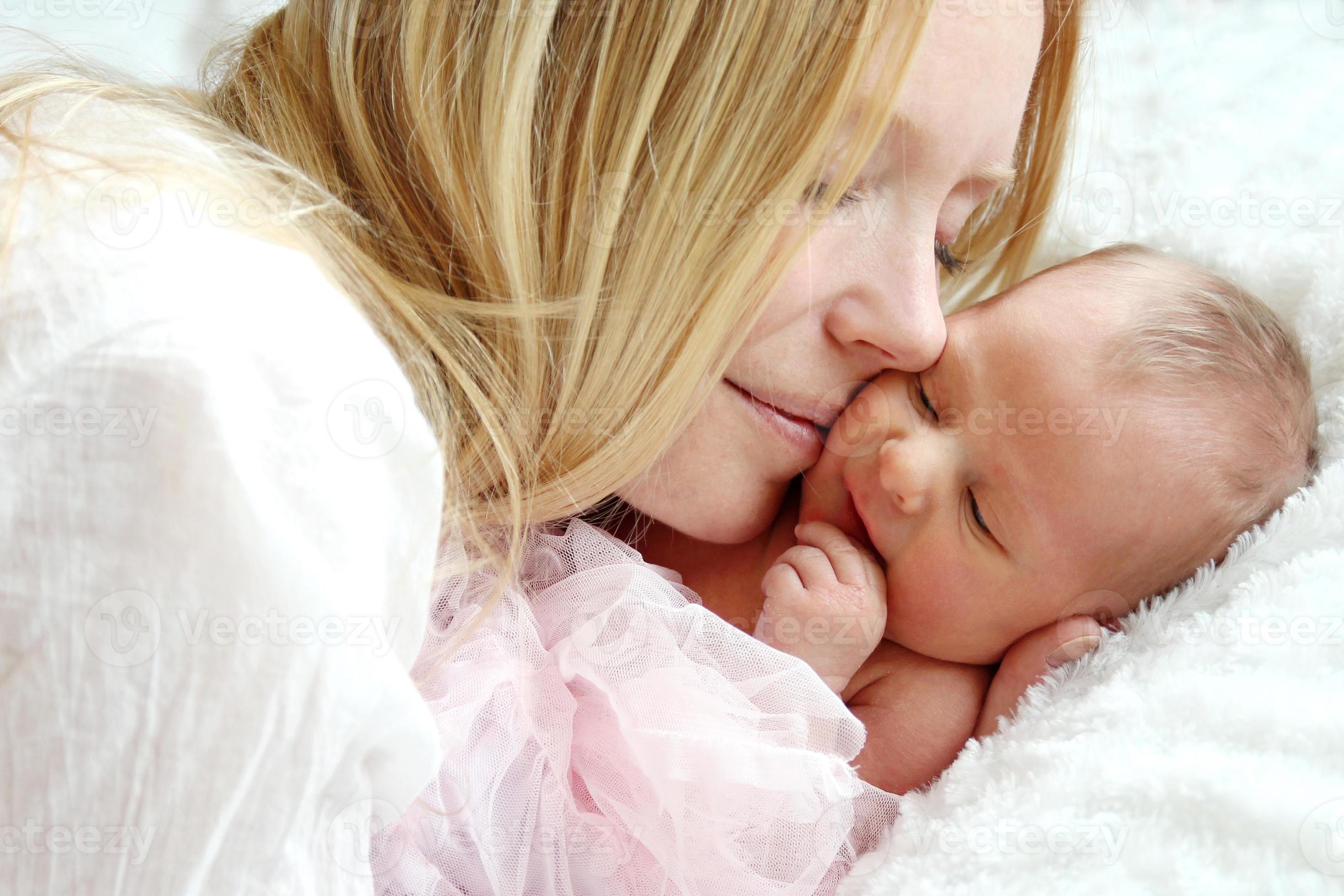 bagageruimte Reisbureau Ontmoedigen gelukkige moeder knuffelen pasgeboren baby in bed 1253807 Stockfoto