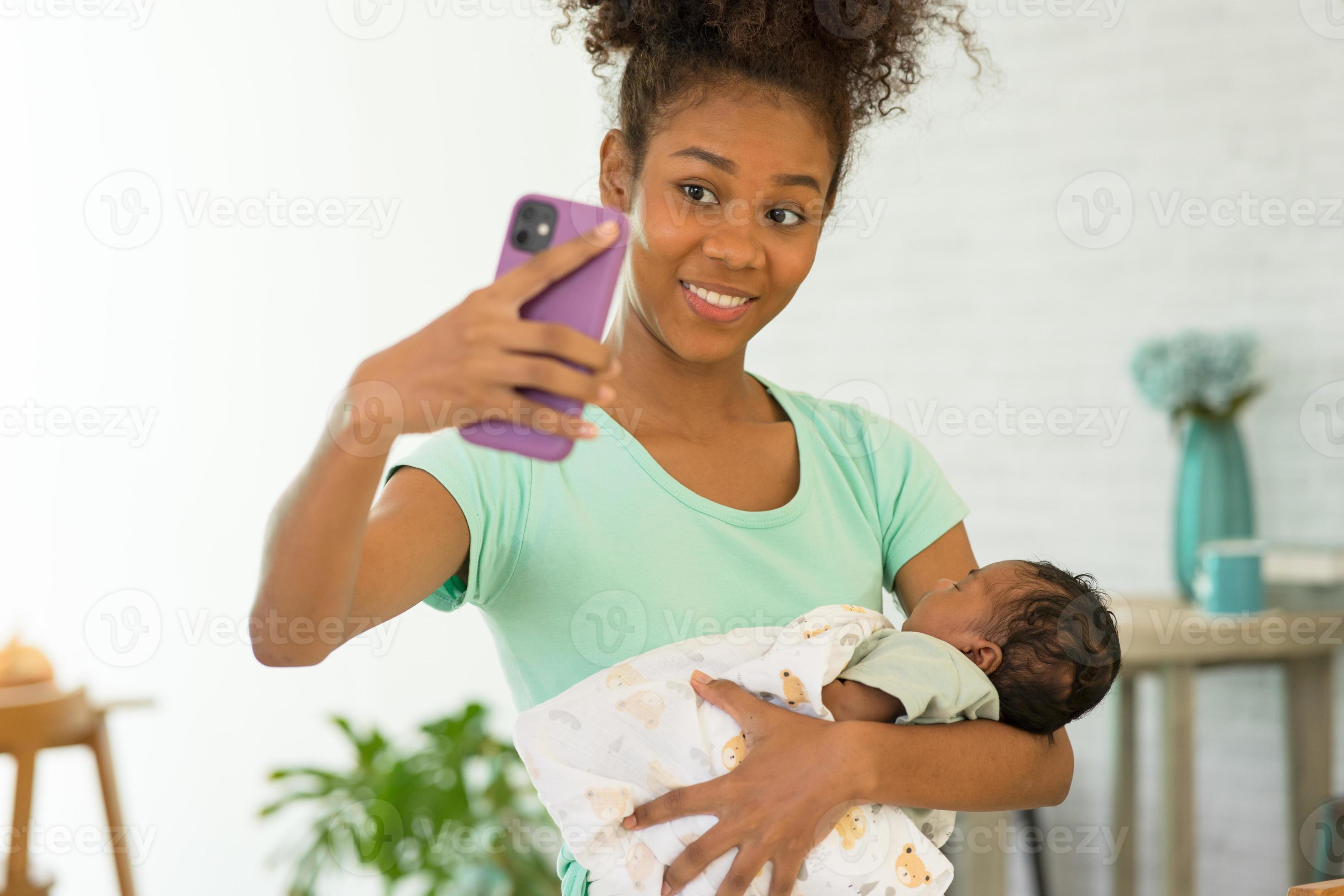 mannetje gehandicapt Aardbei jong moeder en pasgeboren baby maken selfie of video telefoontje naar vader  of familieleden Bij huis terwijl zuigeling slaap goed in warm omhelzing  moederschap. concept van familie nieuw generatie, technologie, verbinding.  13944105