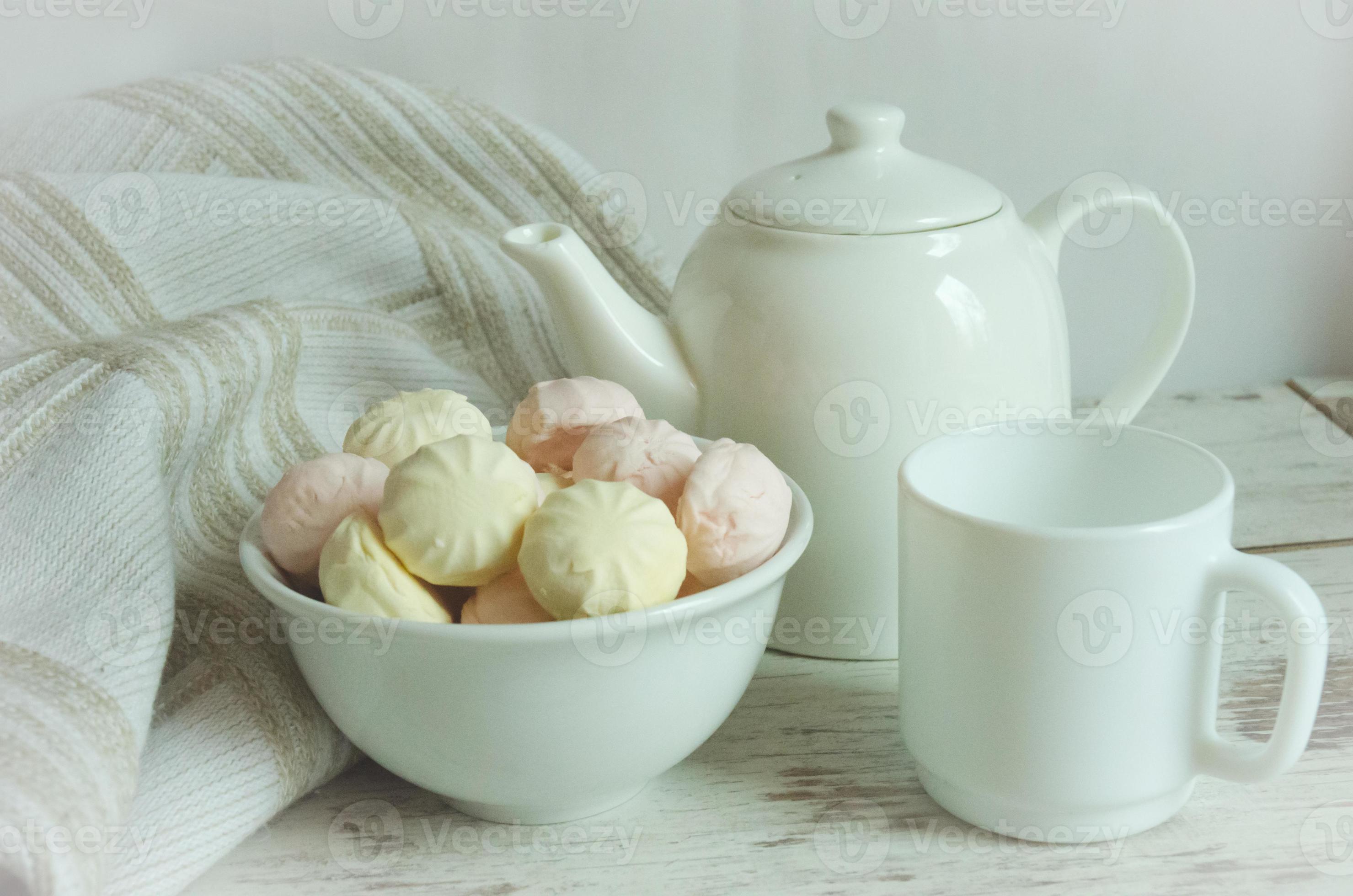 thee partij met marshmallows. waterkoker en thee kop en heemst roze en geel. wit 15468220 Stockfoto