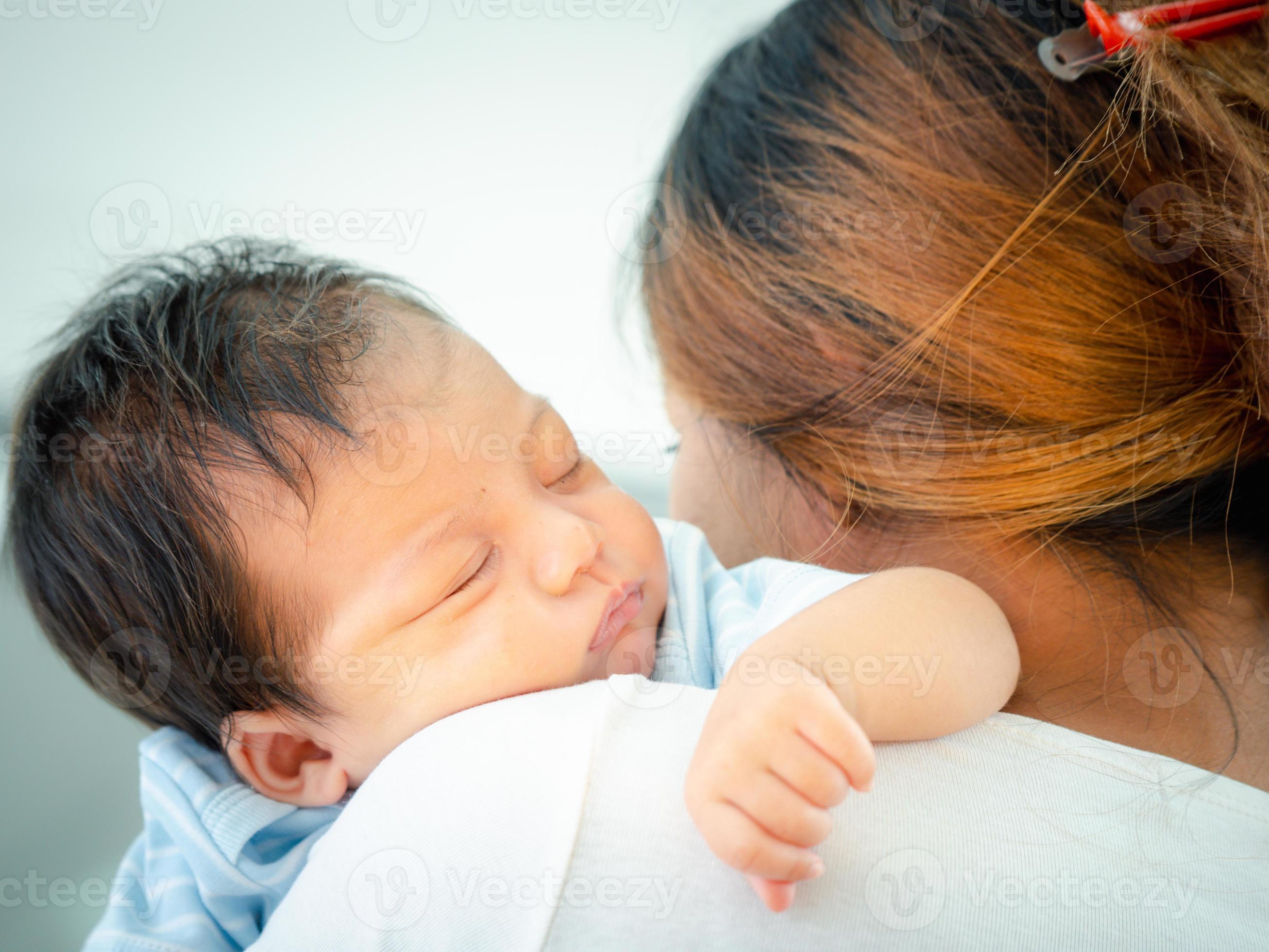 liefhebbend mam draag- haar slapen pasgeboren baby Aan haar schouder Bij thuis.portret van mamma Holding slapen zuigeling kind handen. knuffelen haar weinig twee maanden oud meisje. 16778993 bij Vecteezy