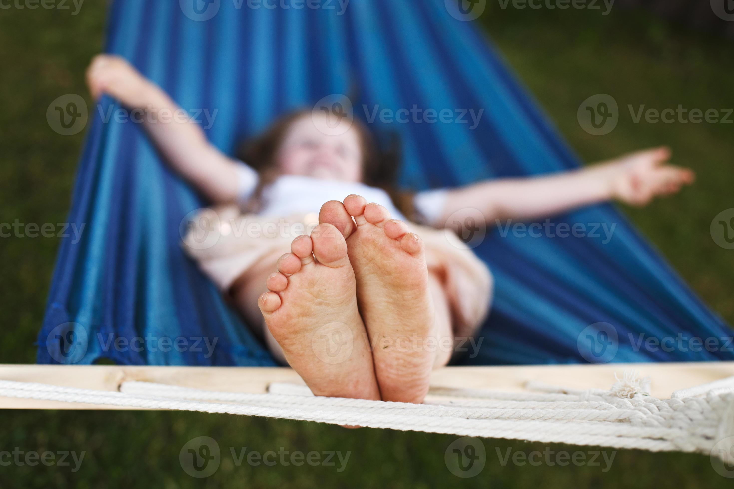 Supplement China bron detailopname van weinig meisjes voeten ontspannende in de blauw hangmat  gedurende haar zomer vakantie in terug werf 17215220 Stockfoto