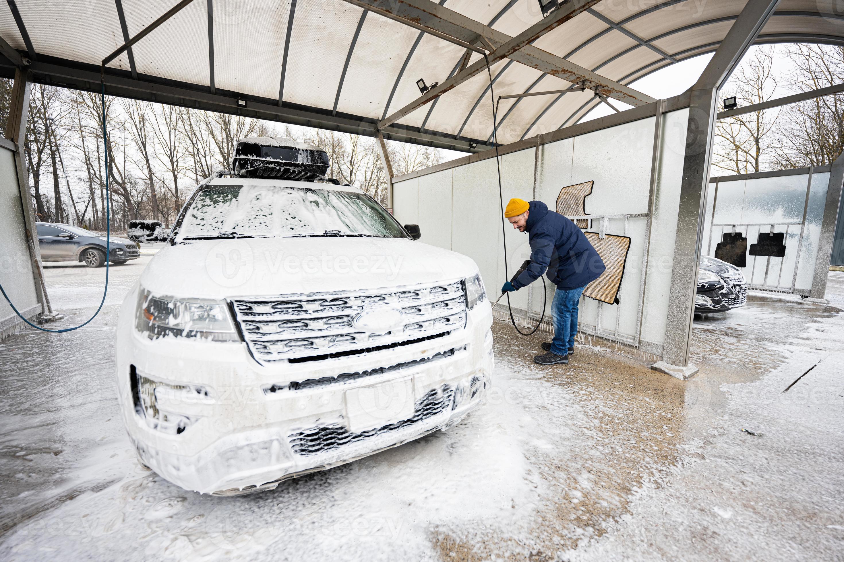 Waarschijnlijk etnisch Geheugen Mens het wassen hoog druk water Amerikaans suv auto met dak rek Bij zelf  onderhoud wassen in verkoudheid het weer. 18788716 Stockfoto