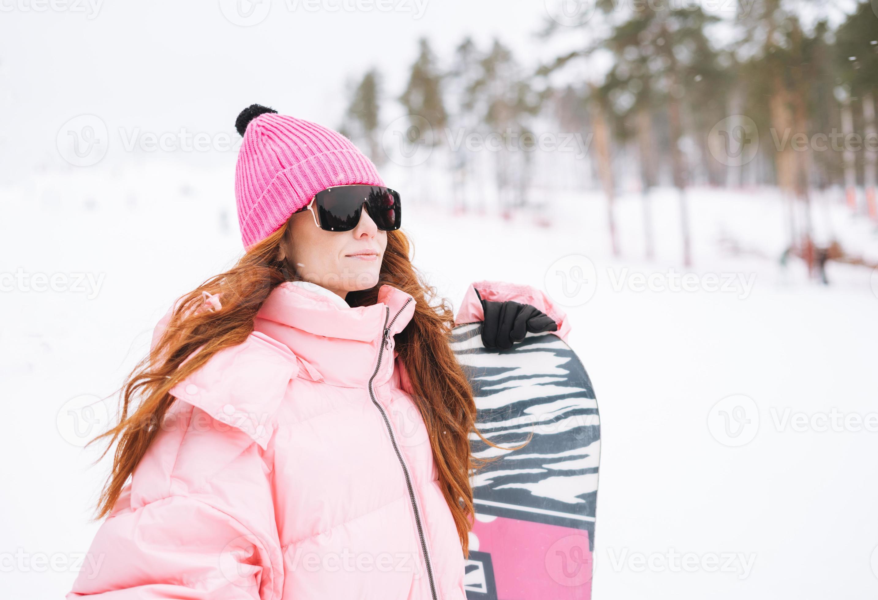 straal orkest bureau jong rood haren vrouw in roze sportkleding met snowboard Aan winter  besneeuwd achtergrond 18902682 Stockfoto