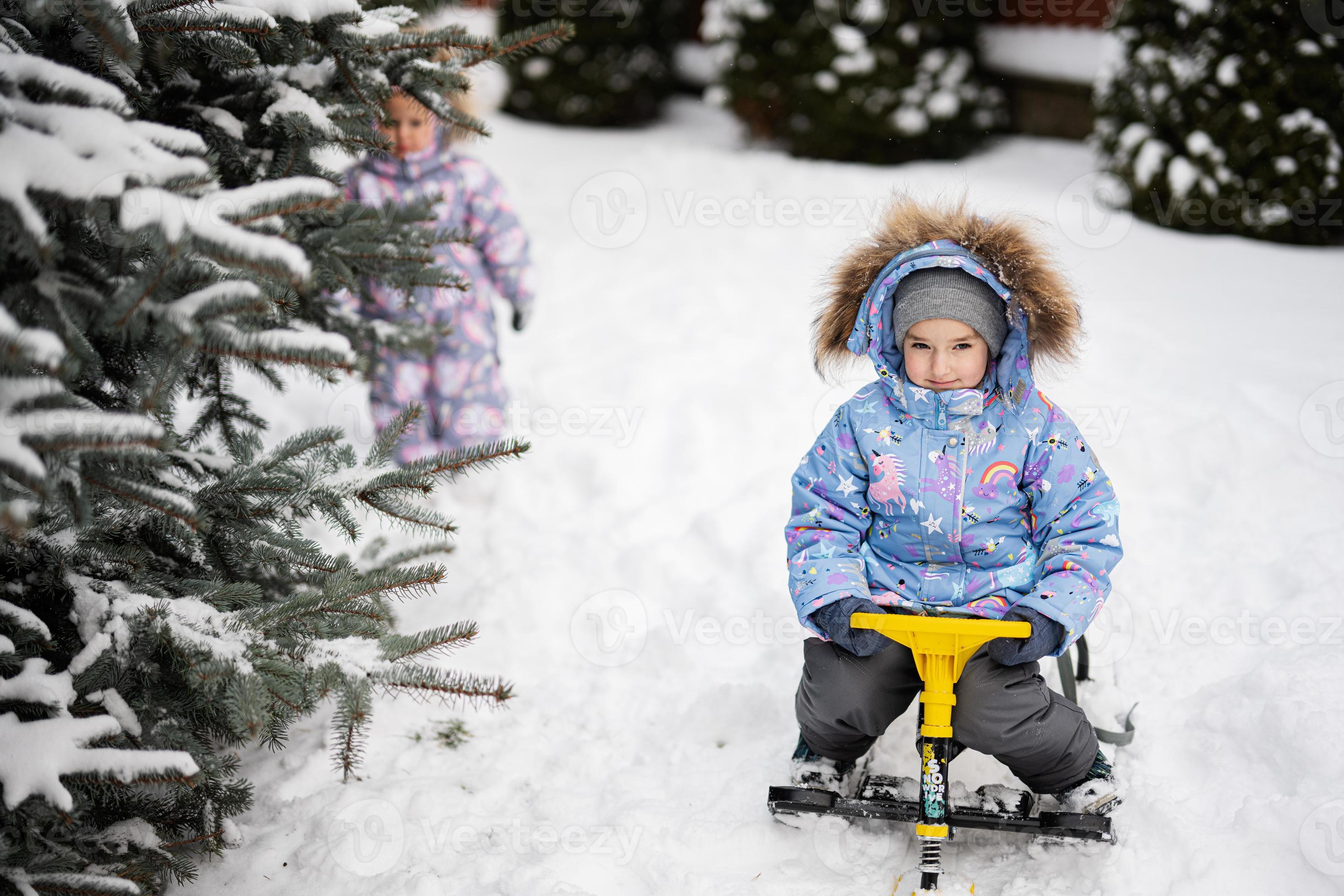 avontuur Populair belasting kinderen Speel buitenshuis in sneeuw. twee weinig zussen genieten een slee  rijden. kind rodelen. kleuter kind rijden een slee. kinderen slee in  winter. 19557842 Stockfoto