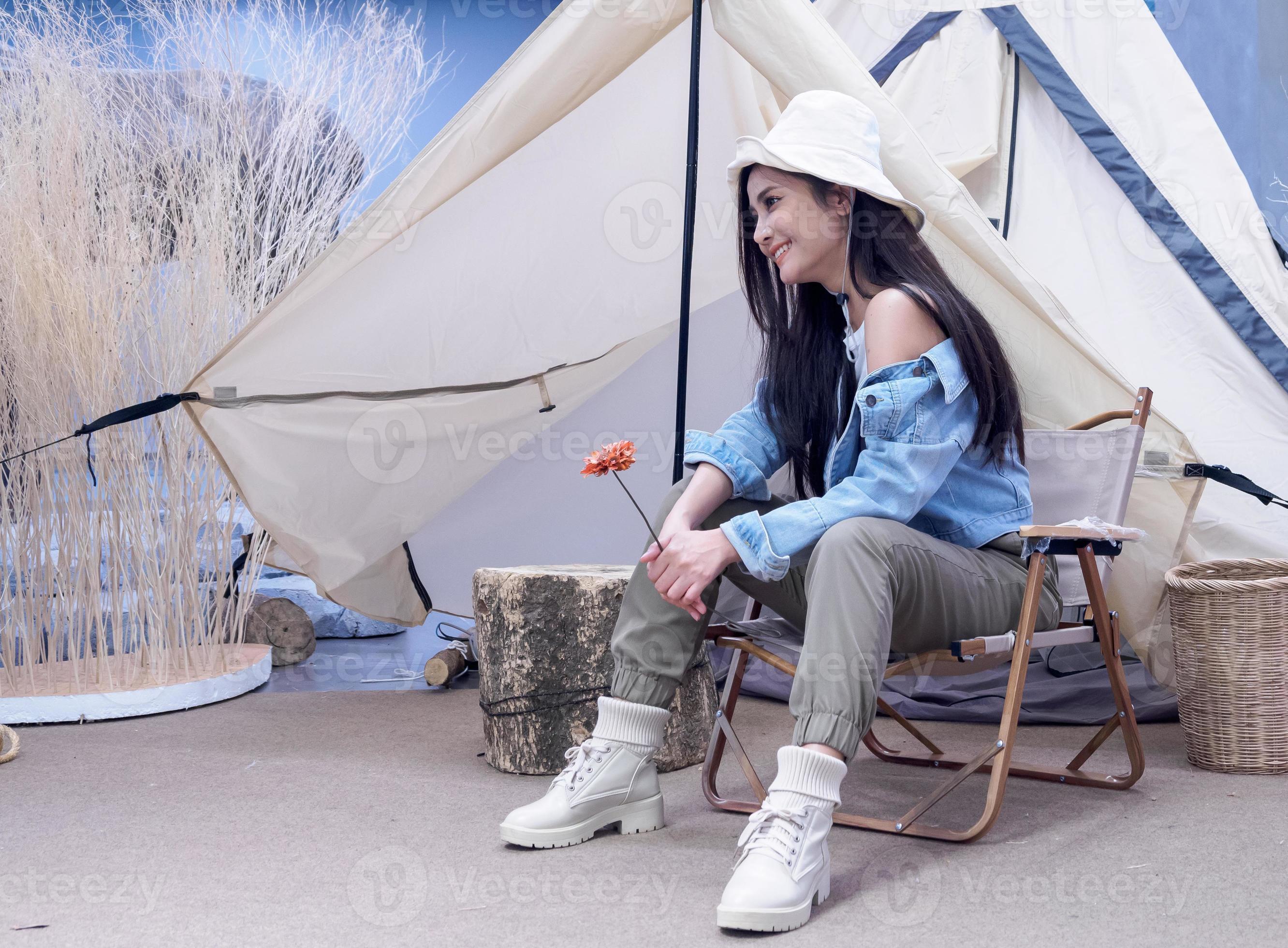 portret mooi jong meisje vrouw Aziatische mooie glimlach met hoed jas blauw een persoon alleen zittend op een stoel camping reis reis voor tent, op vrijheid ontspannen gelukkig genieten in vakantie.