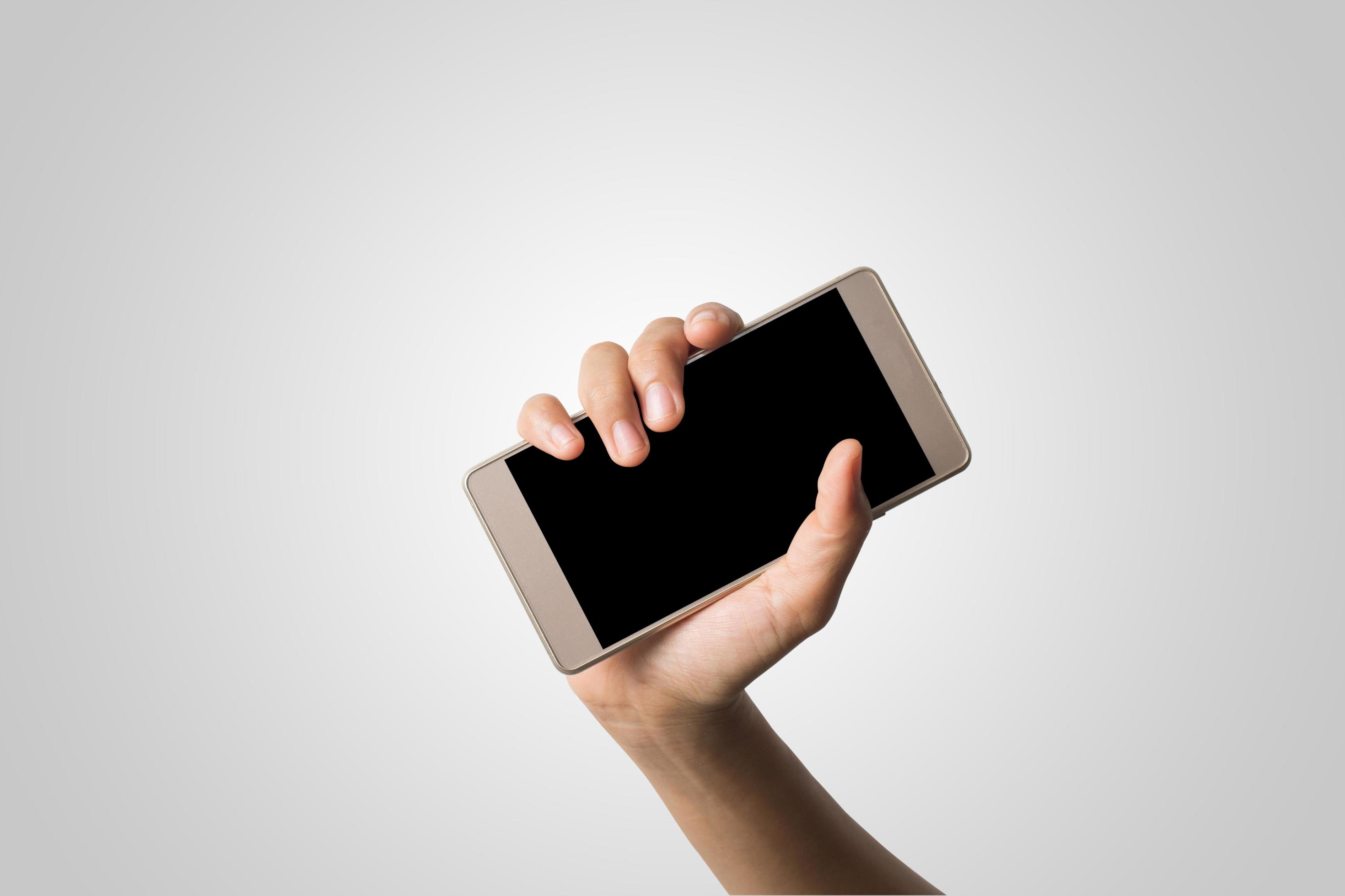 hand met een smartphone met een leeg scherm foto