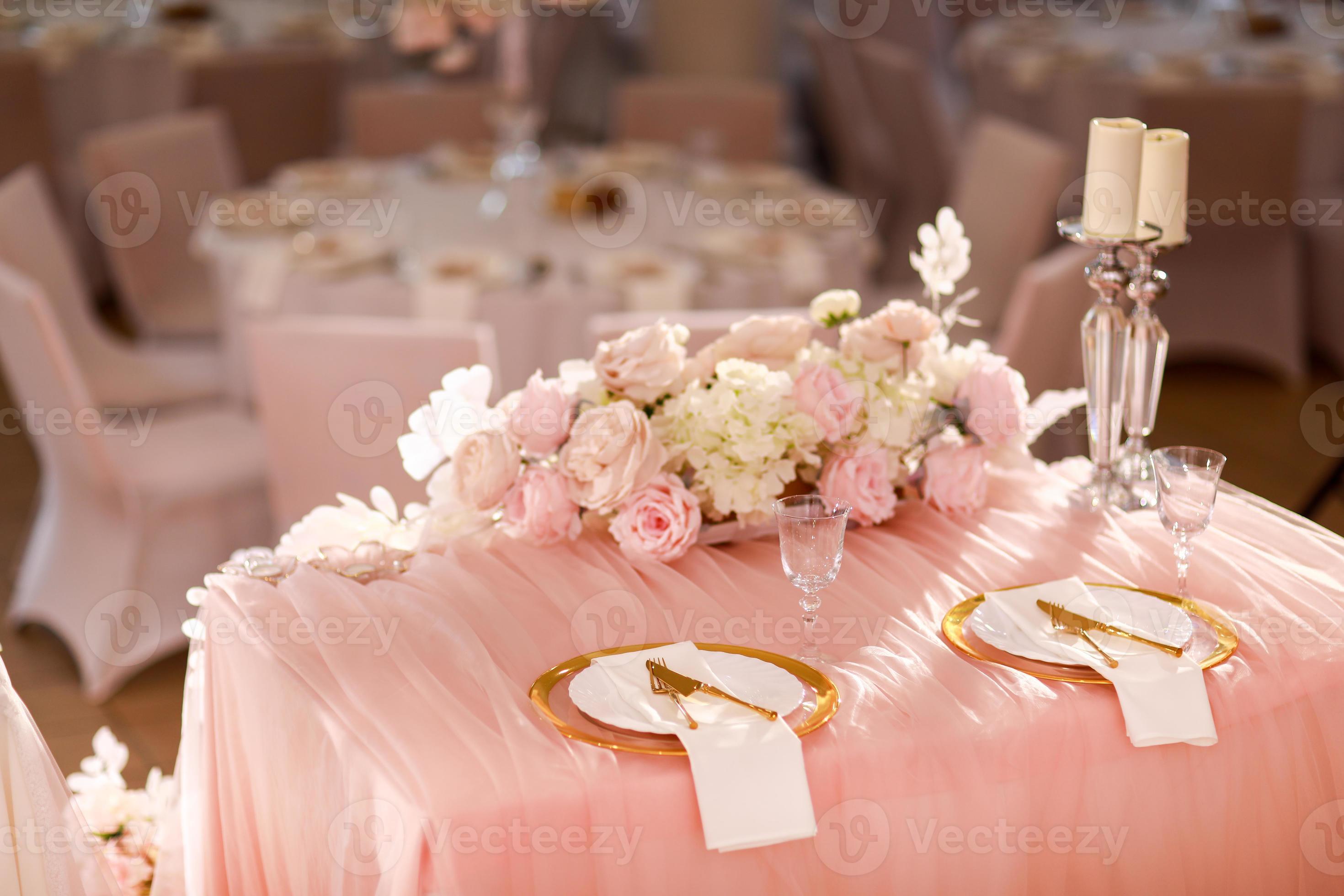 ik wil gat telefoon tafel decoratie met roze tafelkleed, kristal kandelaars met kaarsen en wit  roze bloemen in restaurant . elegant bruiloft dag. instelling tafel met  goud bord, vork en mes 19935526 Stockfoto