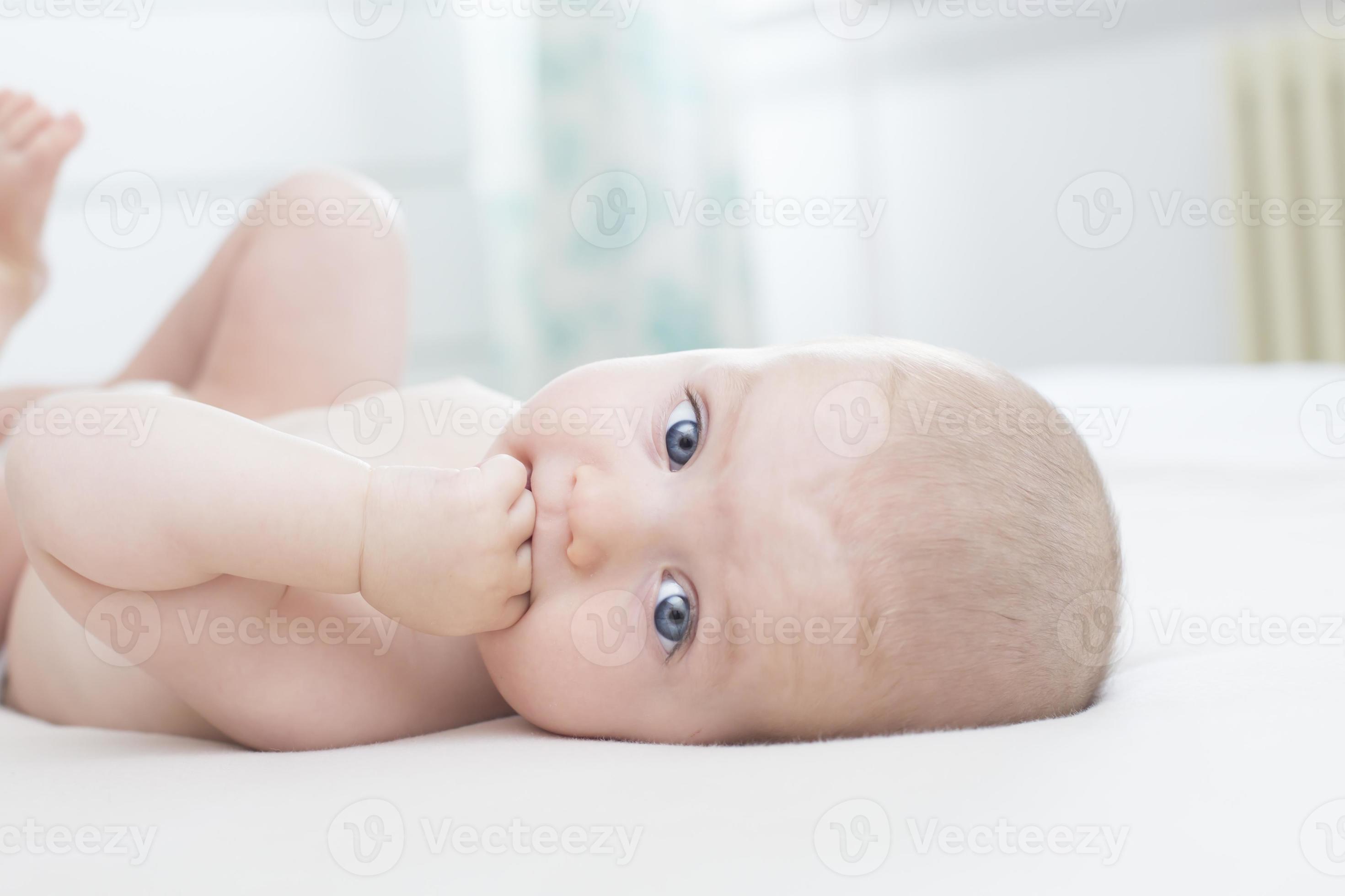 Bedenken Nietje bezoeker babymeisje liggend met hand in de mond 2026820 Stockfoto