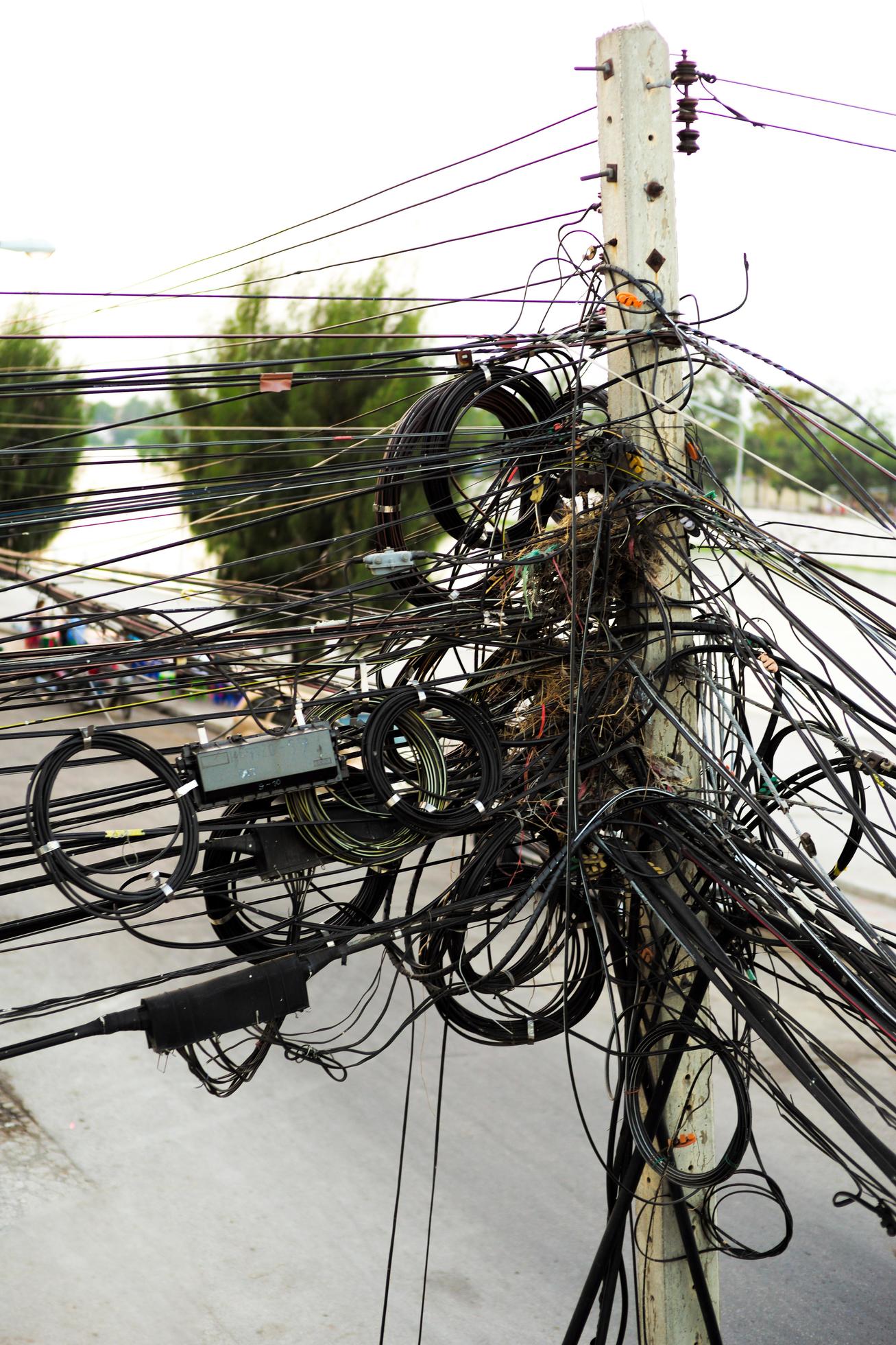 Verslaving Ironisch Acht rommelige kabels in een betonnen elektriciteitspaal naast de weg in de stad  2381502 Stockfoto